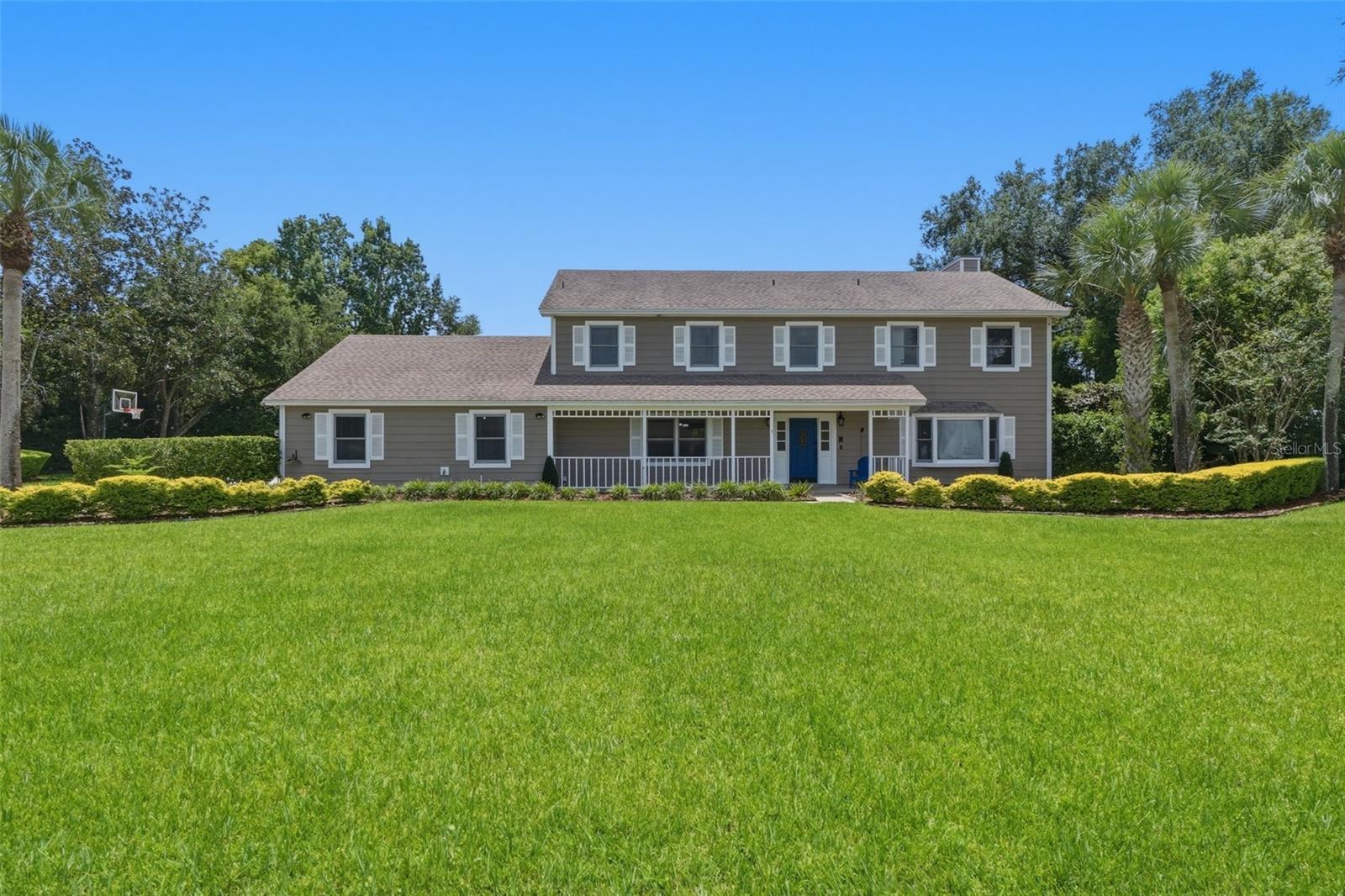 Welcome to your private oasis in one of Longwood’s most coveted acreage communities! This modern farmhouse blends timeless charm with a lot layout that offers a lifestyle of space & freedom. The exterior features a traditional rocking-chair front porch & a desirable 3-car side-entry garage. Step inside the grand foyer to discover elegant French doors open to a spacious formal living room which can also be ideal for a private home office. The separate dining room flows into your gourmet kitchen, featuring light cabinetry, premium granite countertops, stainless steel appliances & a breakfast nook overlooking the grounds. Entertainment is effortless in the cozy family room, complete with a custom wet bar & a beautifully refinished fireplace. Step out to your expansive covered lanai & screened patio deck overlooking a massive, wide-open 1-acre backyard. The home also features a fully renovated downstairs full bath that is structurally pool-planned with a direct-access exterior door. Upstairs, retreat to your primary suite featuring soaring vaulted ceilings, dual walk-in closets & a spa-like en-suite bathroom. Bedrooms 2 & 3 share a Jack & Jill bathroom layout, while the 4th bedroom offers serene views of your sprawling backyard acreage. If you want privacy & elegance on an acre lot, Welcome Home!