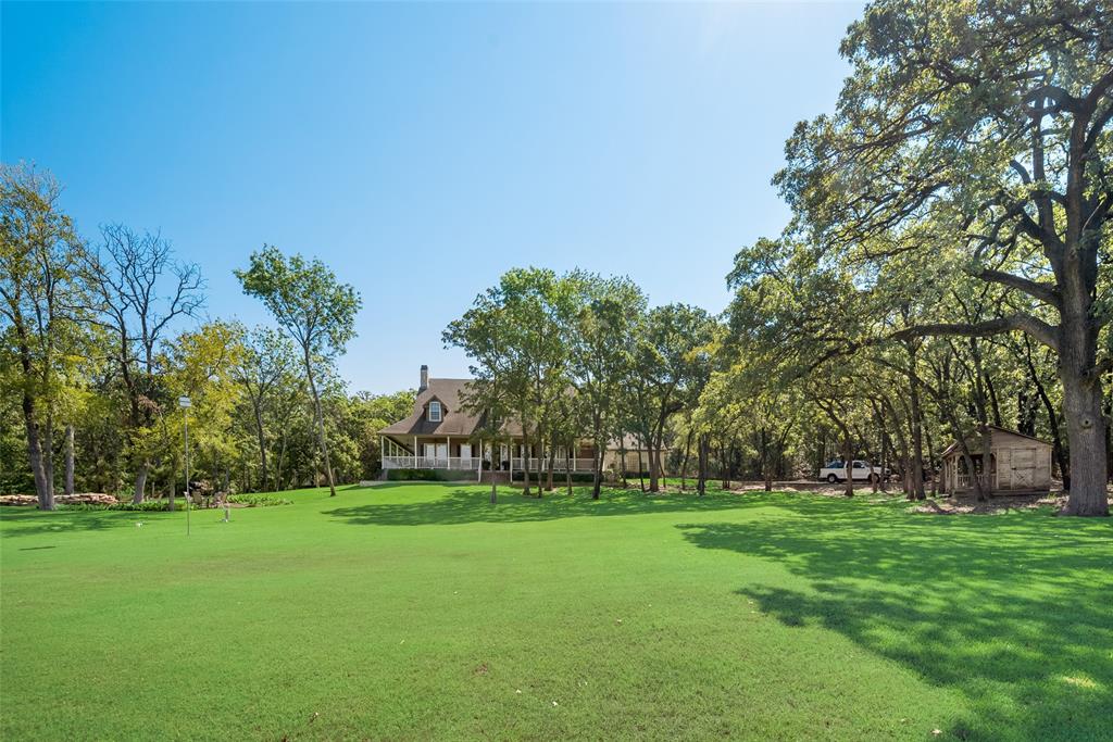 Nestled on a breathtaking 17.867-acre estate, this remarkable offering includes three contiguous parcels featuring a 3,470 SF custom home, a serene 2-acre stocked pond with a fountain, a large creek winding through the land, and a deep water well. Towering trees and lush greenbelts create a park-like atmosphere that's both tranquil and inspiring. A private road with no outlet ensures ultimate seclusion, while still being just minutes from top-rated Keller ISD schools, shopping, and dining. Whether you envision a multigenerational family compound, a palatial private estate, or subdividing for multiple homes (subject to city approval), this rare property offers unmatched flexibility. Enjoy fishing or kayaking in your own backyard, stroll along future trails carved beside the creek, or simply relax and take in the panoramic views of the pond and surrounding woods. The possibilities are truly limitless.