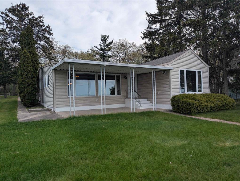 Nestled in the woods off of Michigan Avenue down a secluded street is this spacious home located along the beautiful sandy shores of Lake Huron! This home offers a nicely wooded buffer as multiple backlots are included in the sale. Enjoy 70' of sandy beach frontage along the water with a nice greenspace in between the sandy and the front covered patio of the home. The home offers three bedrooms(including one with a great water view), 2.5 baths, a fantastic open and huge kitchen/living room that has tremendous views of the water and a gas log fireplace. Other features include a large laundry area w/ a convenient 1/2 bath, a basement with storage area or possible extra living space, city water, well for watering, natural gas, new furnace, Generac system, and a new wood seawall at the water. For storage, there's a 2 car detached insulated garage and a storage shed. A fantastic opportunity to get on the lake for enjoyment this summer season as this listing comes with immediate occupancy!!