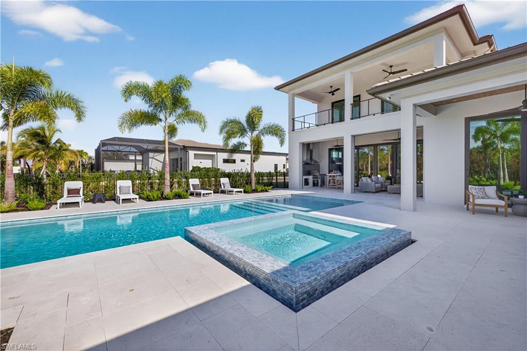 Integrated pool / hot tub featuring a balcony, a patio, glass enclosure, and an outdoor lounge area