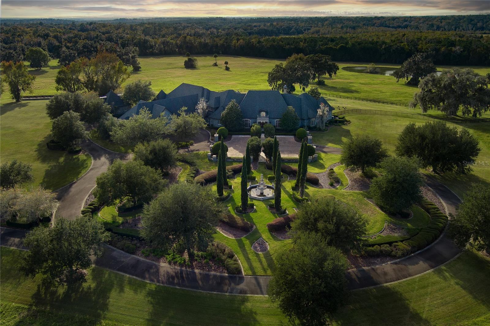 A rare opportunity awaits atop one of the region's highest elevations where this magnificent 560+ acre estate commands breathtaking panoramic views of Florida's pristine countryside. Mardanza Farm features a masterfully-crafted French Provincial main residence showcases exceptional design elements and superior craftsmanship, complemented by extensive additional accommodations across the property. Entertaining reaches new heights with the chef's kitchen, butler's pantry, and luxurious outdoor living area centered around a stunning infinity pool that seemingly merges with the horizon. For equestrian enthusiasts, the property's world-class facilities include four comprehensive barn complexes with integrated living quarters, lush pastures shaded by granddaddy oaks, and a professional Wordley Martin synthetic arena. This extraordinary compound offers multiple luxury residences including a three-bedroom guest house and an elegant duplex with dual primary suites, creating the perfect blend of sophisticated living and equestrian excellence.