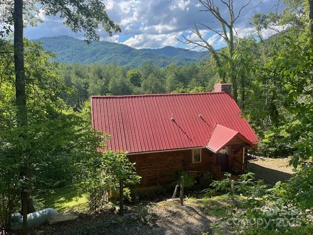 Easy Access Mountain Log Cabin with Views and Features!  This newer 3/2 log cabin is hitting the market for the first time ever, and it has lots of windows, covered deck with views, and that awesome mountain vibe everyone knows and loves! Primary bedroom on main floor with kitchen, dining, living area, and full bath.  Lower level has 2 bedrooms and a full bath, second living Area, and another covered porch! Combination of paved and gravel road with minimal incline and switchbacks for easy access, too! A quick drive to Asheville for its amenities,  and even quicker to the cute little town of Burnsville!