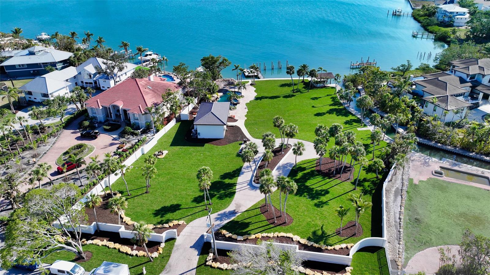 Welcome to the most exclusive waterfront offering in Sarasota—an extraordinary canvas for a visionary estate. Set on nearly 1.5 acres with an unrivaled 400 feet of water frontage overlooking the pristine expanse of Roberts Bay, this North Siesta Key property presents an exceptionally rare opportunity to craft a world-class residence in one of Florida’s most sought-after enclaves.With 64,529 square feet of land (excluding additional submerged land), the site provides city-approved flexibility to be developed as a single grand estate or divided into two premier waterfront homesites. A 12,000 SF concept by MHK Architecture offers just one example of the boundless potential to create a masterpiece with panoramic water views, optimal southern exposure, and every modern luxury imagined.The existing property features an all-weather dock, platform boat lift, rare boat house with lift, and two jet ski lifts, ensuring effortless access to Sarasota’s renowned waterways. Situated on deep sailboat water with no fixed bridges to the Gulf, this is a premier destination for boating enthusiasts. The estate is also walled and gated for ultimate privacy, offering a sanctuary of exclusivity.A 2,600-square-foot modern guest house, alongside a Lucas Lagoon grotto-style pool and tiki hut, can be seamlessly integrated into a new site plan or removed to allow for a completely uninhibited vision. This is not just a property—it is a legacy opportunity to curate an architectural statement in an unrivaled setting. Build without compromise. Live without limits.