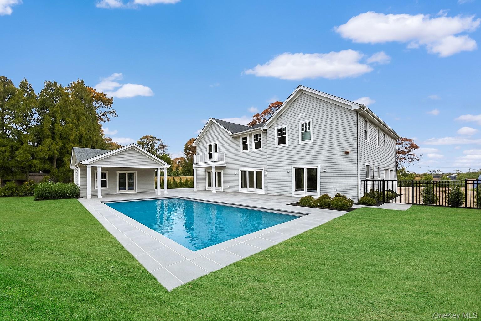 Presenting an exceptional new Hamptons estate, currently under construction and slated for completion at the end of 2025. This bespoke two-story residence spans approximately 6,651 sq. ft. of masterfully crafted living space, blending timeless architectural elegance with modern luxury for the ultimate year-round retreat or seasonal escape.
A dramatic double-height foyer introduces an airy, open-concept great room anchored by a sleek fireplace and lined with expansive glass doors that frame views of the resort-style grounds. The adjoining gourmet kitchen is impeccably appointed with custom cabinetry, premium integrated appliances, and an oversized center island designed for both culinary precision and effortless entertaining. A sophisticated dining area flows seamlessly to the bluestone terrace and outdoor oasis, where a fully equipped kitchen and a beautifully designed pool house set the stage for al fresco living at its finest.
The main level also features a private guest suite, a chic powder room, and an attached two-car garage, ensuring both comfort and convenience.
The second floor is dedicated to luxury, highlighted by a grand primary suite that serves as a true sanctuary. Enjoy a private balcony overlooking the grounds, dual walk-in closets, a dedicated office lounge, and a spa-inspired bath with a soaking tub and designer finishes. Three additional en-suite bedrooms and a well-appointed laundry room complete the level.
The finished lower level provides an additional world of lifestyle options, featuring a generous recreation room, two more bedrooms, a stylish mini-bar, and a secondary laundry room—ideal for extended stays or hosting guests.
This home is also thoughtfully engineered with sustainability in mind, including a state-of-the-art geothermal heating and cooling system for optimal energy efficiency and year-round comfort.
Outdoors, the beautifully landscaped property is designed for relaxation and recreation, featuring a 20' x 40' heated gunite pool, a charming pool house, and lush, professionally curated plantings that create a serene, private setting.
Perfectly situated just minutes from Southampton Village, renowned dining, boutique shopping, and pristine ocean beaches, this property offers the quintessential Hamptons lifestyle—luxurious, effortless, and unforgettable.