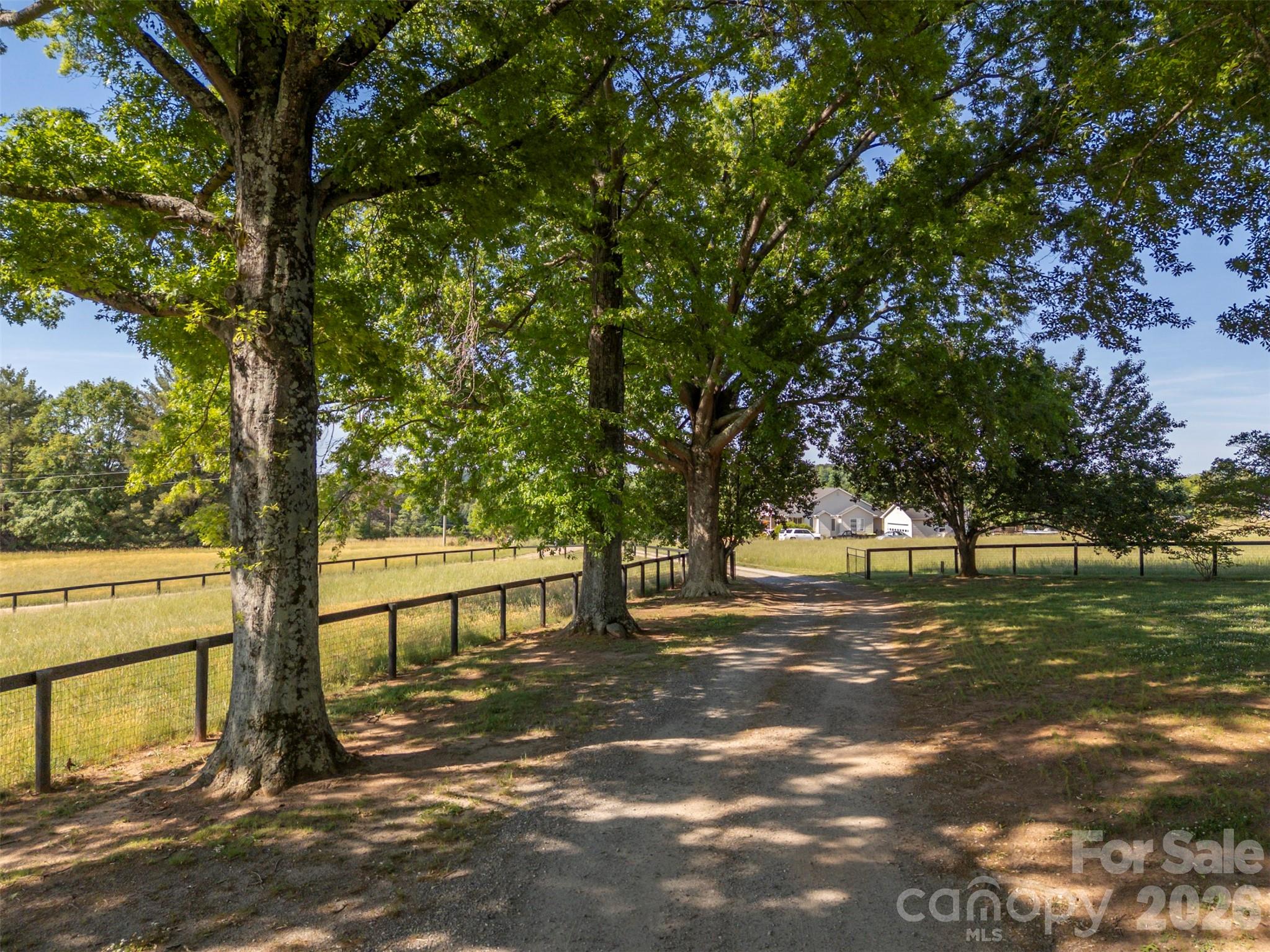 This exceptional Tract of land lies at the end of Breezy Hill Lane not far off Floyd Blackwell, a State Road and also has frontage on McDade Road. It has numerous potential uses, a private estate, horse farm, cattle farm or could be subdivided into smaller farms. The pastures are beautifully maintained currently with three large, fenced pastures each having access to a shared run-in shed currently used for pet goats. A 1300 square foot two-bedroom, two-bath farmhouse is located across from a large two car garage with additional storage space. A 80 x 50 custom building has a 396 square foot loading dock on the backside side with a 12 x 12 door and another 1000-foot loading dock with a 14 x 14 door at one end. The other end has an additional 12 x 12 door. A 2070 square foot covered wrap around equipment storage area tops off the building.  Additionally, the farm has a spring-fed pond, two wells, mature pecan trees and numerous excellent farm/home building sites. There are so many possibilities for this 66+ acre tract of land located just minutes from Tryon International Equestrian Center.