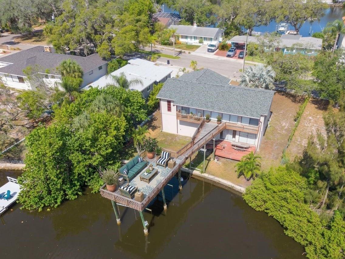 Virtually Staged. Seller says "Bring your best offer."  Experience the best of Florida waterfront living in this 3-bedroom, 2-bath elevated home overlooking the peaceful waters of Minetta Bayou with direct Gulf access. Perfectly positioned in one of Tarpon Springs' most desirable locations, this property offers the ideal combination of breathtaking water views, flexible living space, and the laid-back coastal lifestyle you've been dreaming of.The elevated main living area features a spacious, light-filled open floor plan with a large living room, dining area, and an inviting kitchen complete with bright white cabinetry, generous counter space, and excellent flow for everyday living and entertaining. Step outside to the expansive elevated deck, where you'll enjoy panoramic views of Minetta Bayou while sipping your morning coffee, hosting gatherings, watching local wildlife, or taking in spectacular Florida sunsets.The private primary suite and two additional bedrooms provide comfortable accommodations on the main level, while the home's new roof and hurricane shutters offer added peace of mind.Downstairs, you'll discover an incredible bonus living area with its own second kitchen, making it ideal as a guest suite, in-law quarters, studio apartment, recreation room, home office, or expansive family room. A large storage closet and an oversized 3-car garage provide exceptional space for vehicles, tools, water toys, fishing gear, and all your outdoor equipment.Boaters and nature lovers will appreciate the Gulf access from Minetta Bayou, offering endless opportunities for kayaking, paddleboarding, boating, fishing, and exploring Florida's scenic waterways.Located just minutes from the world-famous Tarpon Springs Sponge Docks, historic downtown Tarpon Springs, Fred Howard Park and Beach, Sunset Beach, the Pinellas Trail, marinas, waterfront dining, boutique shopping, festivals, First Friday celebrations, live concerts, art shows, and year-round community events, this exceptional home places you in the heart of one of Florida's most charming coastal communities. With convenient access to Tampa International and St. Pete-Clearwater International Airports, you'll enjoy easy travel while living where others vacation.Whether you're searching for a full-time waterfront residence, seasonal retreat, or the perfect home for entertaining family and friends, this exceptional Minetta Bayou property offers an unparalleled Florida lifestyle with endless possibilities.