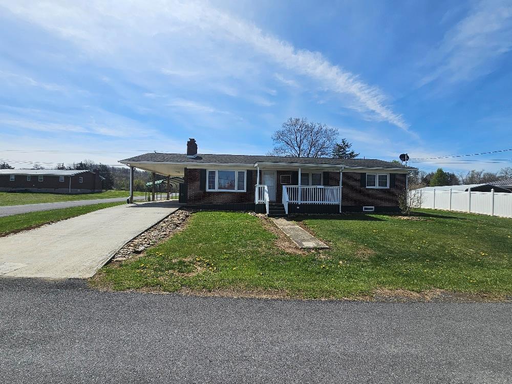 Brick ranch on large level lot that fronts 3 streets.  Four bedrooms and 1.5 baths.  One of the bedrooms has an added half bath in closest space and one bedroom was being used for laundry.  However, laundry could be moved back to the basement area or combined to the room with the half bath.  There is also a large, finished room in the basement that could be used as a den or a bedroom.  The rest of the basement could be finished for extra square footage.  Two large storage buildings, a covered shed, and a metal carport to convey with the sell.  Kitchen features hickory cabinets with granite counter tops.  Enjoy the large screened in back porch for outdoor living space.  New septic tank installed 4 years ago.