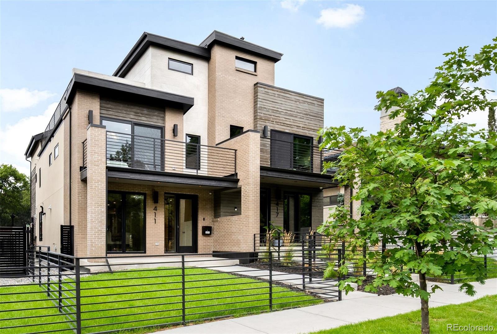 Perfectly situated in the heart of Cherry Creek, this newly constructed residence by MAG Builders captures the essence of modern luxury on a quiet, tree-lined street. Designed across four expansive levels with a private elevator connecting each, the home combines architectural sophistication with everyday livability. The main level is anchored by a showpiece kitchen, where SubZero, Wolf, and Asko appliances complement walnut tambour paneling on the island, a built-in coffee bar, and dramatic quartz countertops. The adjoining dining area opens directly to a welcoming front porch and fully fenced yard, while the living room invites both relaxation and entertaining with a 60” gas fireplace and accordion doors that provide seamless access to the heated back patio and finished 2-car garage. A custom wine room with LED wall paneling and steel and glass doors elevates the experience. Upstairs, the primary suite is a serene retreat with its own balcony, spa-inspired five-piece bath, and generous walk-in closet. A secondary bedroom with an en-suite bath and a thoughtfully placed laundry room complete this level. The third floor offers flexibility for work or retreat, featuring an additional bedroom and bath, a sleek wet bar, and a rooftop terrace with far-reaching city and neighborhood views. The fully finished lower level extends the lifestyle with a warm family room, a full wet bar with SubZero wine column, and a private guest suite. Radiant in-floor heating, curated Visual Comfort lighting, and designer fixtures accentuate the refined interiors, while thoughtful exterior details, including front walk and back patio snow-melt heating systems, ensure year-round comfort and convenience. A finished two-car garage with epoxy flooring and insulated doors provides both function and polish. Just blocks from Cherry Creek’s celebrated restaurants, galleries, and boutiques, this residence presents a rare opportunity to own a home that defines both distinction and convenience.