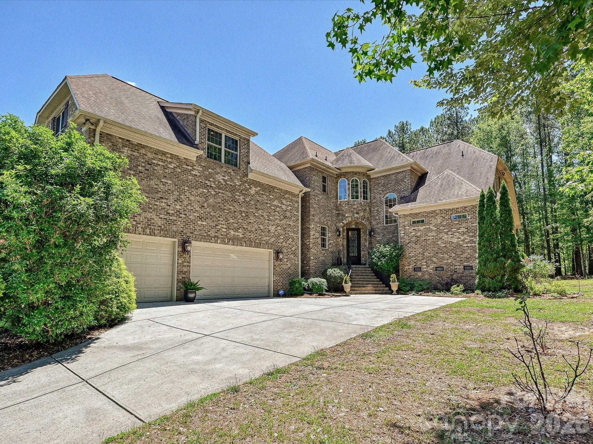 Custom Craftsmanship Meets Lakeside Lifestyle Where Timeless Elegance Meets Modern Shoreline LivingPrepare to fall in love with a home that defines presence.  Located in the highly sought-after Palm Tree Cove, 275 Palm Cove Way is a stunning full-brick and stone custom estate that balances grand architecture with the warmth of a true family sanctuary.  Situated just moments from the shores of Lake Wylie, this 3959-square-foot masterpiece offers a lifestyle of quiet luxury and community convenience.  Make a lasting first impression with the grand entry foyer that leads into a soaring two-story great room with cathedral ceiling, cozy gas fireplace, and French doors that open to a back deck for relaxation and solitude.  Bathed in natural light from a wall of windows, the living space features rich hardwoods that have recently been refinished, intricate exquisite crown moldings can be found throughout the home on ceilings and floors in every room, UV protected and black out Roman blinds, ensuring your home stays cool and your finishes stay pristine.  Luxury is standard here, with a main-level primary suite featuring tray ceilings, panoramic bow windows, an exit door to the back deck, a garden tub with cathedral tray ceiling, massive walk-in shower and oversized walk-in closet space.  Upstairs, the layout is a dream for family or guests; each of the large bedrooms includes its own private full bath and a walk-in closet, offering a level of privacy rarely found in today’s market.  The kitchen is a chef’s delight with high end finishes, a massive island, custom cabinets, a walk-in pantry, stainless steel appliances and plenty of counter space for that holiday party or family gathering.  They say the kitchen is the heart of the home, and this one is no exception!  With an open floor plan, you can enjoy the guests mingling in the great room, while still keeping watch over your menu!  And if that’s not enough, there is also a formal dining room for those extra special occasions you want to remember.This home comes equipped with a state-of-the-art security system securing all entry points and windows with 360-degree camera footage, as well as an irrigation system in the front and side yard.  The mature natural, sustainable, organic landscaping provides solitude and privacy that cannot be found in many new construction homes today, and includes: fig bush, rocks, trees, grass and evergreen ground cover. The tall, dry crawlspace allows for easy access to underneath the house, and there is over 1,200 sq-ft of storage space available in the attic with walk-in access doors to the attic from the bonus room.  For the hobbyist or the adventurer, this home is unparalleled.  The oversized, tall 3-car garage is perfect for larger vehicles, while the community offers secure dedicated storage for boats, RV’s and jet skis.  Allison Park is just seconds down the road with public lake swimming, fishing piers, boat access (4 ramps), public soccer, football and pickleball fields.  After a day on the water, unwind on your low-maintenance Trex deck overlooking a private wooded backyard that is already perfectly sized for a future pool.  Enjoy the community pool, complete with picnic and recreational areas, and walking trails for the whole family.   Located in the award-winning Clover School District (including the new Lake Wylie High School), you have the best of both worlds; top-tier education and the benefit of low South Carolina property taxes.  Just a short commute to Charlotte Douglas International Airport and Downtown Charlotte, quaint restaurants and every day shopping.  From the central vacuum system to the brand-new 2025 hot water heater and new windows, no detail has been overlooked.  275 Palm Cove Way isn’t just a move – it’s an ARRIVAL! Whether you are a lake enthusiast or a lover of fine craftsmanship, this home is the rare find you’ve been waiting for.  Come see the view for yourself and call it HOME!