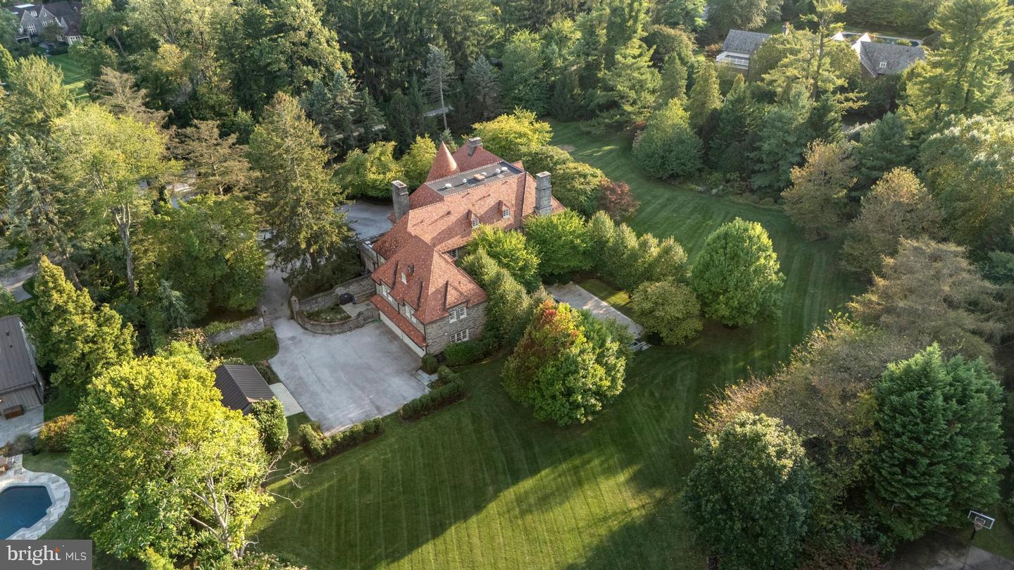 This quintessential Main Line estate, sits on more than 3 level acres of charming English gardens, rolling lawn, hedge fencing and tree lined entrance on a premier street. The stately Pennsylvania fieldstone home with its ludowici tile roof stands perfectly on the property. Completely refinished by Ed Mahoney Builders, the finished product impeccably saved the beauty of the old while bringing every functioning piece to modern excellence. Whether indoors or out, there is endless grand scale or intimate entertaining. Family friendly mudroom (including separate cubbies, deep drawers and individual electronic hubs), high ceiling lower level with outdoor access (including a theatre/media room, bar/kitchen and a 3000 bottle capacity climate controlled wine cellar), nanny suite, exercise studio, original plaster moldings, commercial kitchen,  irrigation, camera system, landscape lighting, marble finishes, study, sunroom and mahogany library are part of this fine residence.  652 Creighton Road is included in this sale and offers a modern pool house/ carriage house with vaulted ceiling, kitchen and Living Space and a Bedroom and Bath.  Oversized double doors open to a heated salt water pool with flagstone patio.