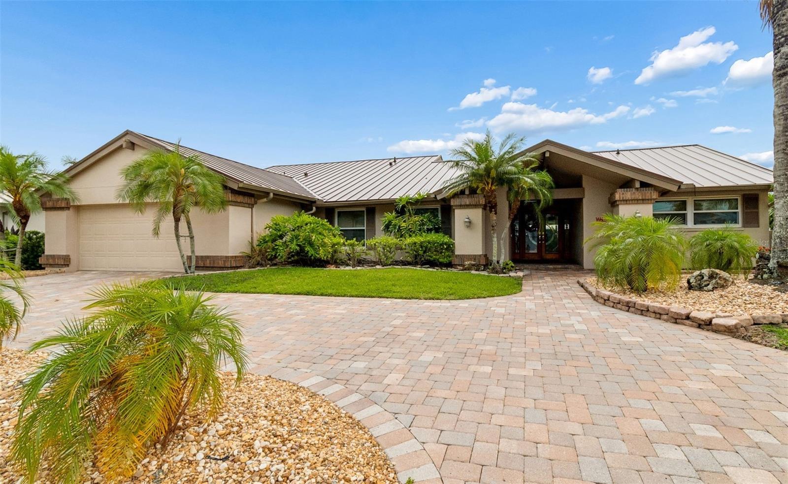 Luxury home on a DEEP-WATER CANAL  with 125 ft of water frontage in the gated community of Sweetwater Creek at Rocky Pointe. 2800 sf Arthur Rutenberg pool home with DIRECT ACCESS to Tampa Bay. Upon entering this home, you are greeted by views of the pool and waterfront from the spacious living room with beautiful GAS FIREPLACE. A METAL ROOF was installed in January of 2026 and Sunburst shutters were installed on all windows in 2024.The Master suite opens conveniently to the HOT TUB AND POOL. The ensuite has an open shower, large soaking tub, double sink, plenty of storage, with a private bathroom and 2 large walk-in closets. Two additional bedrooms with large closets and a spacious hall with a large closet and a 2nd bathroom with a walk-in shower. Call for an immediate showing.There is a LARGE BONUS ROOM which can be utilized as an office or 4th Bedroom.The expansive kitchen with quartz counter tops has a gas range, new refrigerator, dishwasher and double oven.Additional upgrades include a GAS TANKLESS WATER HEATER, new Daikin A/C, and a whole house water softener.All windows and sliding glass doors have been replaced with Pella products.A new electrical panel was installed and the existing panel was upgraded to accommodate the home and dock.The outdoor living space includes a SALTWATER POOL AND HEATED SPA, large built in gas grill, pergola, lighted pool area and a separate play house.A 10,000 lb. boatlift is outfitted for a Tri toon pontoon boat and a large Trex deck which provides a gateway to Tampa Bay for fishing water sports or a casual cruise. Private dog run on the side of the house. Also available is a very low hour Tri toon pontoon boat.Only a 10-minute drive to Tampa International Airport, renowned Berkeley Preparatory School, Veteran’s Expressway, and the Courtney Campbell Causeway.  The world-famous PINELLAS COUNTY GULF BEACHES are only 30 minutes away. Call for immediate showing.
