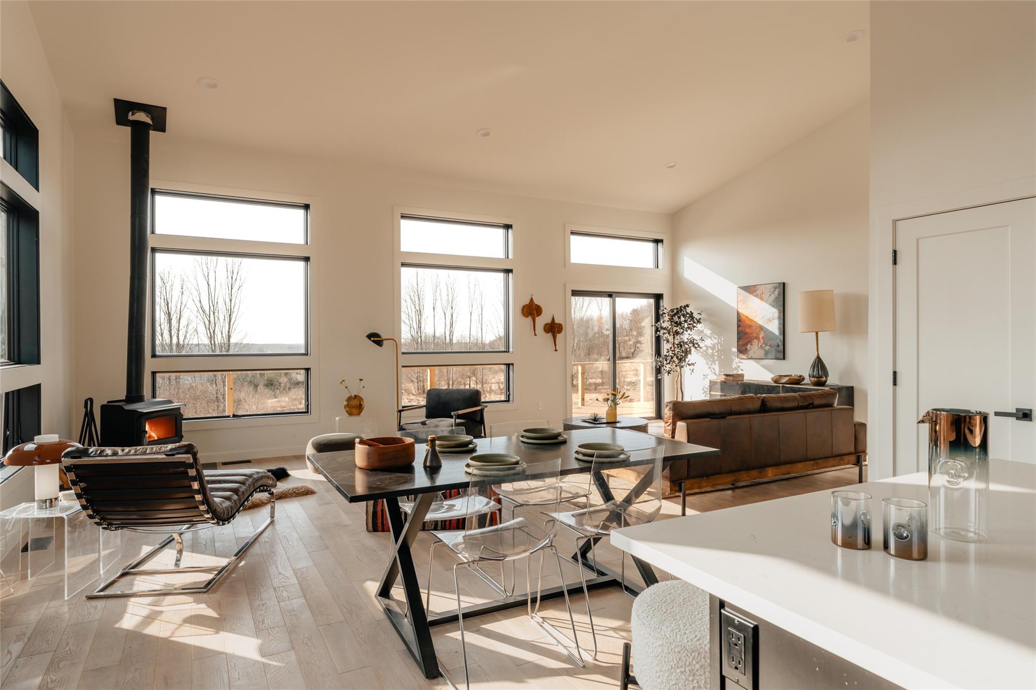 Living room featuring a wood stove, light wood finished floors, and high vaulted ceiling