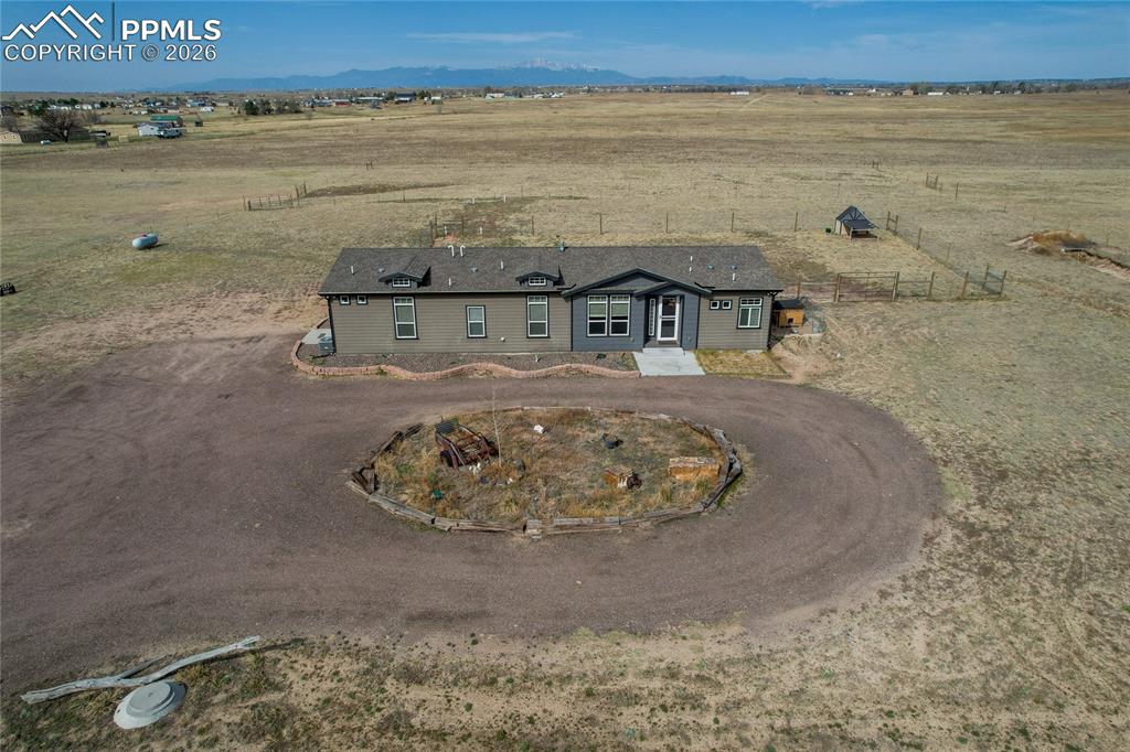 Experience the freedom of wide-open Colorado living—37 acres of equine-ready land just minutes from city conveniences. This beautifully upgraded ranch-style home delivers true main-level living with modern finishes, thoughtful functionality, and unforgettable Pikes Peak views.Inside, you’re welcomed by a cozy family room with shiplap walls, built-ins, and custom bookshelves. The gourmet kitchen is built to impress, featuring a gas range, vent hood, pot filler, expanded island, upgraded cabinetry, separate pantry, and abundant storage—all flowing into the dining area and out to an expansive patio ideal for sunrise coffee, BBQs, and Colorado evenings. The primary suite is a true retreat with a spacious walk-in closet with a center island and a luxurious 5-piece bath featuring a spa shower and soaking tub. Two additional bedrooms, a full bath, flex office/family space, and a smart laundry/mudroom with exterior access complete the home. RV hookups are available at both the house and the barn.Outside is where this property becomes truly rare: an impressive barn with 12’ steel walls, tack/feed room, pre-plumbing for hot water, multiple outlets, LED lighting, exterior motion lights, welded steel tie areas, and a concrete cross-tie wash station. Five frost-free hydrants are placed across the acreage. You’ll also love the double-entrance riding arena, covered pens with 20’ runs and bull gates, multiple shelters, quarantine pens, large paddocks, steel loafing sheds, plus a ¼-mile equine track and regulation-size polo field. Perimeter fencing is wired for electric fencing—ready for your setup.This is the kind of property that doesn’t come around often. Schedule your private tour today—come walk the land, tour the barn, and see what 37 acres of possibility feels like in person.