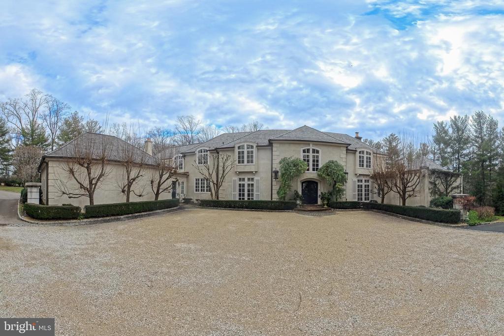 Situated in the heart of Gladwyne, this distinguished residence offers timeless architectural elegance and thoughtfully curated indoor and outdoor living spaces. A grand double-door entry opens to a marble-tiled foyer with soaring ceilings and a sweeping staircase.The formal living room is highlighted by a dramatic two-story ceiling and expansive floor-to-ceiling windows. A beautifully appointed office features custom wood built-in bookshelves and a fireplace with a striking black marble surround. A second living room, ideally located near the kitchen, is rich in character with cathedral ceilings accented by wood beams, custom wood paneling, detailed crown molding, a fireplace, and a built-in bar alcove, creating an inviting setting for entertaining.The kitchen is equipped with custom cabinetry, granite countertops, a Dacor gas cooktop, and a         double-door custom Sub-Zero refrigerator. The dining room is a true showpiece, featuring a hand-painted mural ceiling, dual chandeliers, and oversized doors that open to the back patio.The first-floor primary suite offers a serene retreat with direct backyard access and two ensuite bathrooms, including an updated spa-like bath with a walk-in shower, bench seating, and overhead shower, as well as a second bath with a soaking tub and walk-in shower. Upstairs, six additional bedrooms are complemented by multiple full bathrooms, including several updated baths.The finished basement adds flexible living space with a recreation area, home gym, and full bath. Outdoor living is elevated by a pavilion-covered patio designed for year-round enjoyment, featuring a substantial brick fireplace with built-in TV, a pool, and professionally landscaped grounds. A three-car garage completes this exceptional Gladwyne offering.