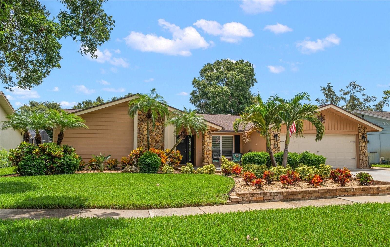 Back on the market with a reduced price and stunning new upgrades, including beautifully renovated master bath, stylish new light fixtures, renovated hall bath and more! Nestled in the desirable and beautifully kept Clearwater neighborhood, Northwood West, this Campagna-built residence combines prime location with resort style living. Professional tropical landscaping and fresh exterior paint create head turning curb appeal, while a covered entry ushers you into a bright open floor plan and interiors awash in new luxury vinyl plank flooring, fresh paint and natural light. Designed for multigenerational flexibility, the open layout centers on a newly renovated  eat-in kitchen flaunting white wood cabinets, quartz counters, stainless appliances, cove lighting, and an oversized island with a breakfast bar. Sliders leading out to the enclosed sparkling pool and a large covered porch, make entertaining family and friends effortless. The adjacent family room exudes coastal warmth with its stone fireplace, shiplap feature wall, and built-in coffee bar, while the formal dining room also spills out to the pool for seamless entertaining. A sunlit primary retreat enjoys private slider access to the lanai, a generous custom closet, and a spa inspired ensuite highlighted by a subway tiled walk in shower and furniture inspired vanity. Four additional bedrooms provide endless possibilities—including a separate in law or nanny suite—complemented by exquisitely renovated baths, one doubling as a convenient pool bath. Outside, a mature hedge and lush landscaping promises privacy, and practical upgrades abound: impact rated windows and doors, whole house generator-2021, gas tankless water heater-2021, indoor laundry, new epoxy coated garage floor-2025, all new lighting, new interior and exterior paint-2025, roof-2021, Main AC-2020, blown insulation in attic-2025, and more. Minutes to shopping, dining, two airports, and the Gulf’s world famous beaches, this turnkey tropical haven is the one everyone’s been waiting for—act fast before it’s gone!