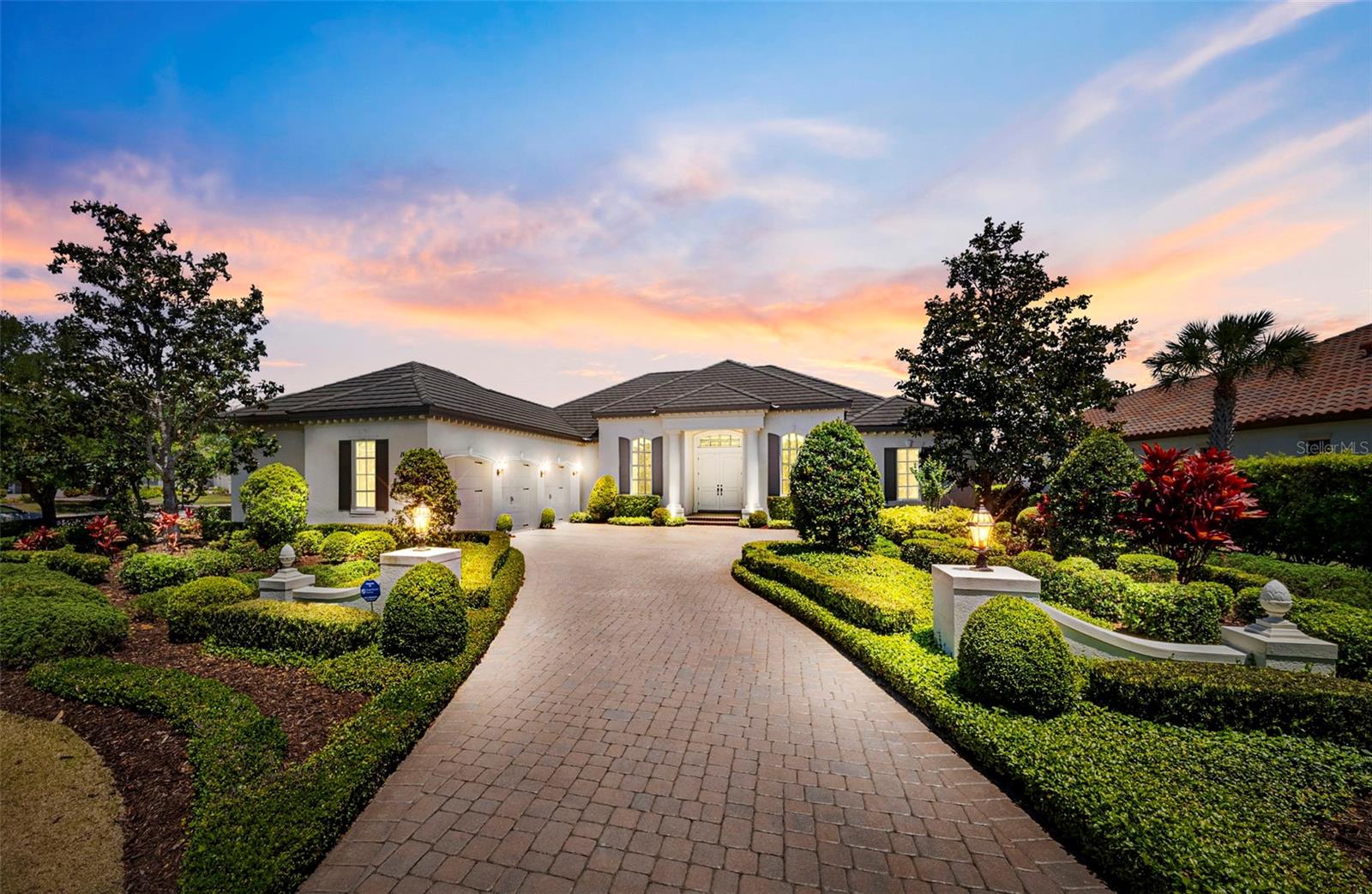 Welcome to 16204 Daysailor Trail, an extraordinary custom John Cannon residence nestled within the prestigious, gated community of The Lake Club in Lakewood Ranch — where timeless elegance, lush surroundings, and an unparalleled lifestyle converge. Set on an impressive 0.59-acre homesite framed by private, mature landscaping and backing to a serene park, this meticulously maintained home offers gorgeous water views, a sense of seclusion that is truly rare, and the kind of refined living that simply cannot be replicated. From the moment you step inside, the architectural details and quality of craftsmanship are undeniable. Soaring ceilings create an immediate sense of grandeur throughout, while high-gloss porcelain tile flows through the principal living areas, crown molding and chair rail detailing add layers of sophistication, and large windows bathe every room in glorious natural light. At 2,861 square feet, this thoughtfully designed 3-bedroom, 3-bathroom home also features a dedicated office, a formal living room, and a family room and separate dining room — all appointed to the highest standard. The formal dining room is nothing short of spectacular, anchored by a stunning crystal chandelier that transforms every dinner party into an occasion. The spacious kitchen is equally impressive, boasting stone countertops, a generous eat-in area, a bar top for casual gatherings, and a large walk-in pantry to satisfy even the most discerning home chef. The adjacent family room flows effortlessly from the kitchen, creating the perfect open setting for everyday living and entertaining alike. The family room is airy and comfortable, featuring an elegant electric fireplace and direct access to the expansive lanai — where a beautiful pool and multiple seating areas invite you to relax, entertain, and soak in the tranquil water views beyond. Whether hosting guests or savoring a quiet evening, this outdoor space delivers the Florida lifestyle at its finest. Retreat to the primary suite, a true sanctuary of comfort and luxury. Two generous walk-in closets, a sprawling bedroom with plush carpet underfoot, and a spa-inspired bathroom come together to create a private escape that feels like a five-star retreat every single day. Practical elegance is woven throughout every detail of this home — from the three-car garage to the SmartShield Homes security system and from the whole-home Generac generator to the gas tankless water heater, ensuring both comfort and peace of mind in equal measure. Beyond your private oasis, The Lake Club delivers a lifestyle that rivals the world's finest resort communities. The magnificent Grande Clubhouse features a restaurant, bar, fitness center, spa services, tennis and pickleball courts, a pro shop, dog park, half-court basketball, and miles of beautifully landscaped walkways — all within one of the most stunning gated communities in all of Lakewood Ranch. This is more than a home — it is a masterpiece of custom design, an address of distinction, and an invitation to enjoy a quality of life you have always dreamed of. Come sink into luxury and make 16204 Daysailor Trail your own.
