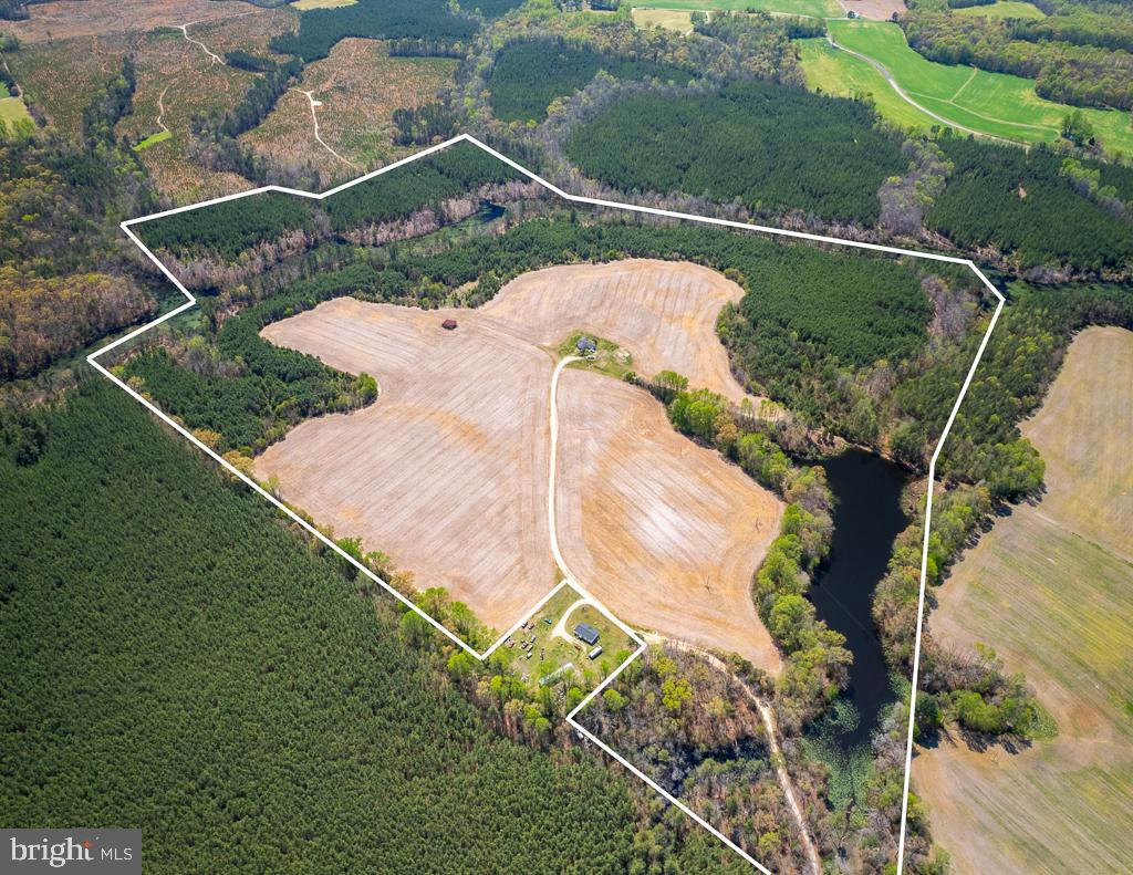 Exciting opportunity to own this 119.75-acre farm offering a blend of recreational, agricultural, & residential potential. A sportsman’s dream, the land features great whitetail & waterfowl hunting, a private 6+ acre pond with fantastic fishing, & a mix of productive cropland & managed timberland—perfect for anyone looking to invest in land & make outdoor memories that last a lifetime. Accessed via a dirt road from Sparta Rd., the property is conveniently located just 20 minutes from Bowling Green for restaurants, grocery stores, shopping, banking, & even a firearms store. The Rappahannock River, Fredericksburg, & Richmond are all within 1 hour, making this a highly functional & accessible property. FSA data indicates approximately 39.17 acres are in crop rotation & leased by a local farmer. Buyers must not disturb the lessee’s crops, which remain personal property until harvest & removal. The VDF reforested 45 acres in loblolly pine over 10 years ago, providing excellent bedding cover for deer, small game, & long-term timber value. The private pond flows into the surrounding King & Queen Swamp, creating a natural sanctuary that wraps around the property, offering ideal duck habitat, year-round water sources for wildlife, & a natural setting for friends & family to explore. Whether you’re in a duck blind at sunrise or casting a line with your kids at sunset, this land invites you to unplug & enjoy life outdoors. A 1,260 sq. ft. cinderblock house with 2 BR, 1 BA, well, & septic provides a basecamp that could be gutted & transformed into a hunting cabin or weekend escape. The condition of the home, well, & septic is unknown & all convey AS IS. An old survey is on record at the courthouse & attached in the MLS. Acreage is based on county GIS mapping & deed references. Newly recorded easement will be uploaded to MLS. Whether you’re looking for a productive farm, a family hunting property, or an outdoor playground—this property has it all! Shown by appointment only-contact the listing agent to schedule your showing!