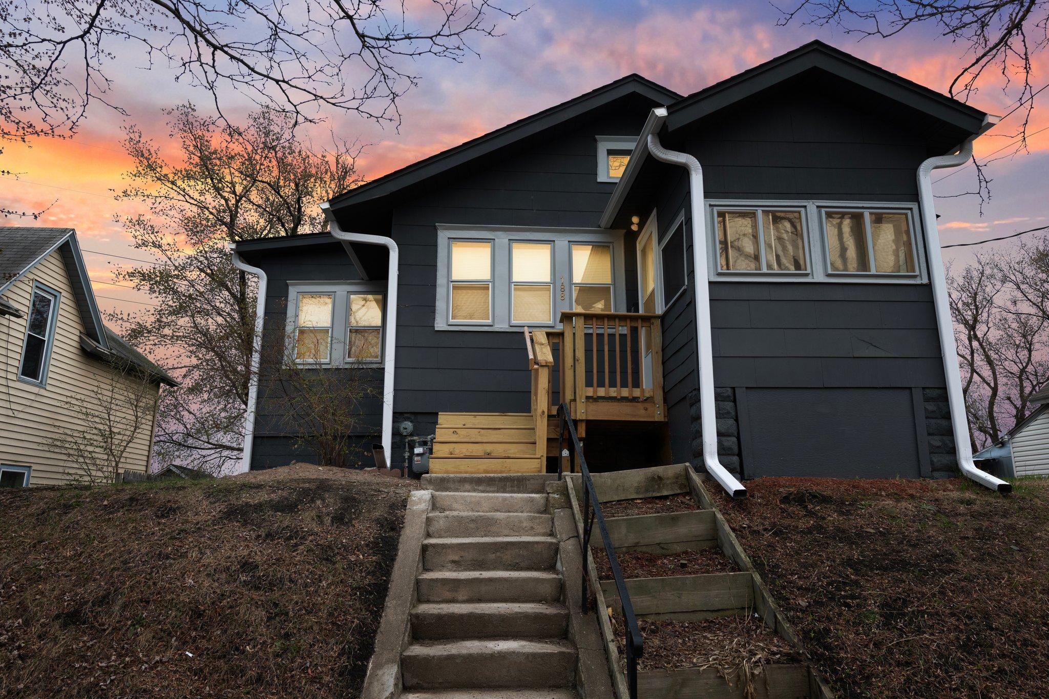This charming two-bedroom, one-bathroom home offers cozy, quaint living on a quiet, low-traffic street in the heart of St. Paul.  The kitchen features luxury plank flooring, white cabinetry, and a gas stove, with a window offering views of the side yard. The dining room, located next to the kitchen, features carpeting and is lined with windows that fill the space with natural light — a perfect spot to enjoy a meal. The living room features warm luxury plank flooring, a ceiling fan, and is conveniently situated next to a three-quarter bathroom.
The shared three-quarter bathroom features luxury plank flooring, a single vanity with storage, and a walk-in shower with tile surround. Bedroom one, which could also serve as a sunroom, is lined with windows that invite natural light, offers ample closet space, features tile flooring, and provides direct access to the 14x8 deck. Bedroom two located at the front of the home adjacent to the living room is fitted with carpeting, ceiling fan and views of the side of the home. This home also boasts a spacious backyard with a 10x9 shed and a 14x8 deck, perfect for relaxing or entertaining outdoors.