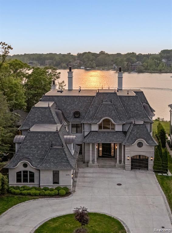 Experience ULTIMATE LUXURY LAKEFRONT LIVING in this one-of-a-kind French Chateau, masterfully designed by Corey Campbell & built in 2019 by Trademark. Perfectly situated on the tranquil part of all-sports Cass Lake, this architectural gem offers over 7,382 sq ft of finished space, plus 3,623 sq ft of a fully finished walkout lower level—blending timeless elegance, thoughtful function, and grand-scale entertaining.
Step into the dramatic two-story foyer with a sweeping spiral staircase, custom balcony, & statement chandelier. Panoramic lake views greet you from the expansive great room featuring curved floor-to-ceiling windows, stepped ceilings, and a built-in 2 way fireplace wall that sees through to the library.
The formal dining room exudes classic charm designer wall detail with hidden elevator access to all floors, a striking chandelier, seamlessly connecting to a bar & sunlit breakfast nook. The gourmet kitchen impresses with custom cabinetry, Sub-Zero, Wolf, Thermador appliances, Miele coffee station, & double oversized islands.Relax in the cozy sunroom with a third fireplace, stunning windows opening to terraces & connecting to screened outdoor covered lanai off library. The upper level hosts four spacious lakeview bedrooms with en suite baths & balconies, including a lavish primary suite with fireplace, sitting area, spa bath, steam shower, & massive double walk-in closets. The walkout lower level is a retreat of its own offering media room, bar, second kitchen, gym, game room,wine cellar, sauna, &pool/lake changing area. Additional highlights include, dual staircases, mudroom with built-in lockers, doggy quarters, a grandfathered all year dock, generator, incredible facade with limestone, shaker, metal turrets, copper finials & designer shingles. Lower level walks out to motorized screened in cabanas, outdoor kitchen, control 4 smart home speakers, blinds, music throughout indoor/outdoor, pool, spa, fire table, & endless outdoor entertainment green space.