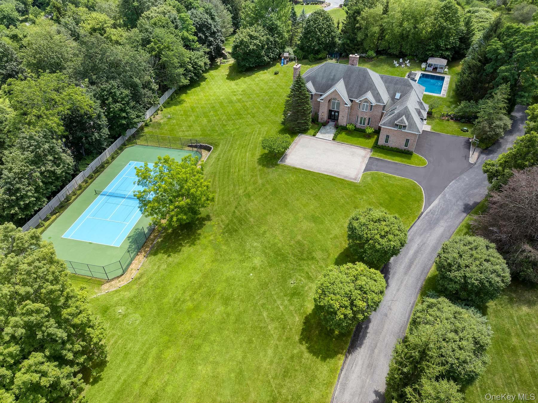 Nestled behind a gated entry on nearly three private acres in Armonk, this stately brick colonial offers a world of refined luxury and total seclusion.  The property blends timeless architecture with modern sophistication—and delivers resort-caliber living at every turn.

Outdoors, the amenities rival any private club: a regulation tennis court with pickleball lines, sparkling in-ground pool with adjacent spa, and a fully outfitted outdoor kitchen and dining pavilion -perfect for alfresco entertaining all year round. A cozy firepit lounge sits under the canopy of mature trees, ensuring privacy and tranquility.

Inside you are greeted by fully renovated interiors. Every detail has been thoughtfully curated—from the sleek, contemporary finishes to the rich textures of custom woodwork and classic architectural accents. Soaring ceilings and oversized windows bathe the expansive living areas in natural light, highlighting exquisite finishes – from gleaming hardwood floors and substantial millwork – all testaments to the home’s artisanal detail. The gourmet chef’s kitchen is a showpiece unto itself, featuring top-of-the-line appliances, custom cabinetry, and a vast quartz-topped center island which flows seamlessly into a sun-drenched two-story family room.

For formal occasions, enjoy the elegant dining room and gracious living room with fireplace. The first-floor office/library offers a private escape for work or reflection. Integrated smart-home automation allows seamless control of lighting, climate, and security with the touch of a button. Additional highlights on the first floor include a mudroom/laundry room and a guest/au pair bedroom with a separate entrance.

Ascend the grand staircase to discover luxurious private quarters. The primary suite is a haven of indulgence, boasting its own fireplace, oversized closets, and a spa-inspired bath clad in marble. Each additional bedroom is oversized with its own ensuite bath- except for two that share a stylish Jack and Jill bathroom. With flexible bonus spaces including a dedicated art room and playroom.

Leisure and wellness take center stage on the lower level. Enjoy cinematic experiences in the custom home theater, wet bar, fully equipped home gym, therapeutic infrared sauna or unwind in the dedicated massage and wellness room.

The estate is as functional as it is beautiful. Designed for both grand entertaining and intimate everyday living, this exceptional property seamlessly merges indoor and outdoor luxuries to create an unparalleled lifestyle experience. A long, tree-lined, double width driveway leads to an attached three-car garage. Just minutes from Armonk’s charming downtown and situated within the highly sought after Byram Hills School District. With a commute of under an hour to the heart of Manhattan, you can truly enjoy the best of both worlds: tranquil country living with easy access to the city. In every sense, 839 Mount Kisco Road is a one-of-a kind retreat that exemplifies luxury living at its finest.
