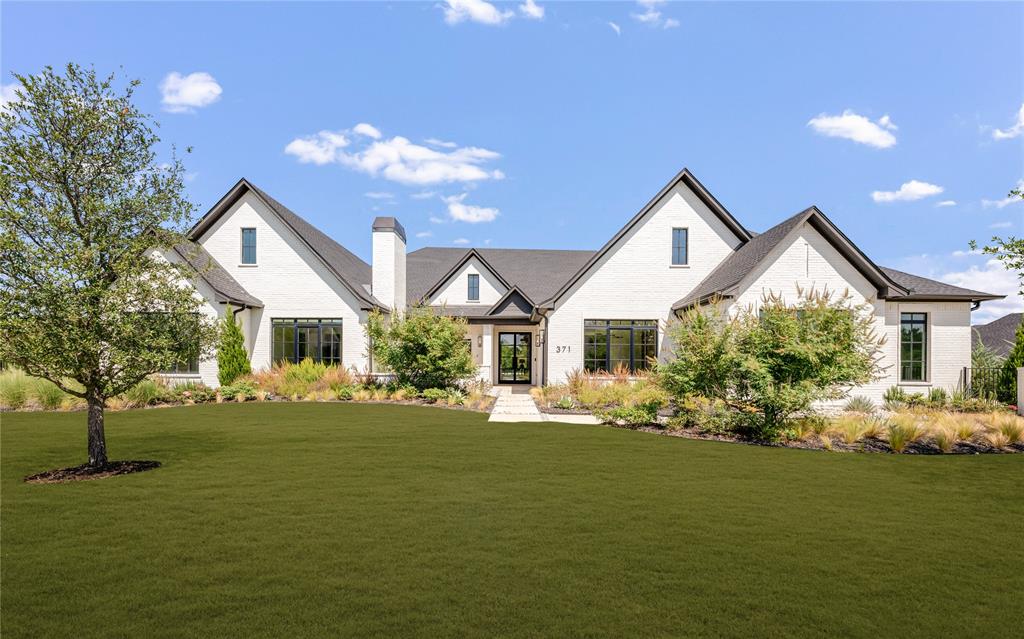 371 Broadwing Drive is an extraordinary luxury estate in Hawks Wood, offering 7,026 square feet of refined single story living on 1.002 acres, plus an additional 1,200 square feet currently designed as a golf simulator room. With 5 bedrooms, 5.2 baths, 4 car garage, and exceptional designer finishes throughout, this impressive residence pairs grand scale spaces with thoughtful amenities and beautifully executed details at every turn. Soaring vaulted ceilings, abundant natural light, wide plank wood floors, designer lighting, and custom architectural elements define the interiors. The expansive kitchen is a showpiece with dual islands, high end appliances, built in refrigerator, extensive custom cabinetry, and an impressive prep kitchen offering additional storage and workspace. Open living and dining spaces flow seamlessly together, while a private office, fitness room, media room, game room, and oversized golf simulator room provide exceptional versatility. The luxurious primary suite features a fireplace and a spa inspired bath with a freestanding tub, oversized shower, dual vanities, and an expansive custom closet. Each secondary bedroom enjoys its own ensuite bath and walk in closet, creating privacy and comfort throughout. The backyard delivers a true resort style experience, centered around a new pool and beautifully landscaped grounds. An expansive covered outdoor living area features an outdoor kitchen and fireplaces, while an intimate courtyard offers multiple settings for dining, relaxing, and gathering. The fully fenced acre also provides generous lawn space and mature trees. Located in Hawks Wood, the property offers the privacy and space of acre living with convenient access to shopping, dining, and major thoroughfares.