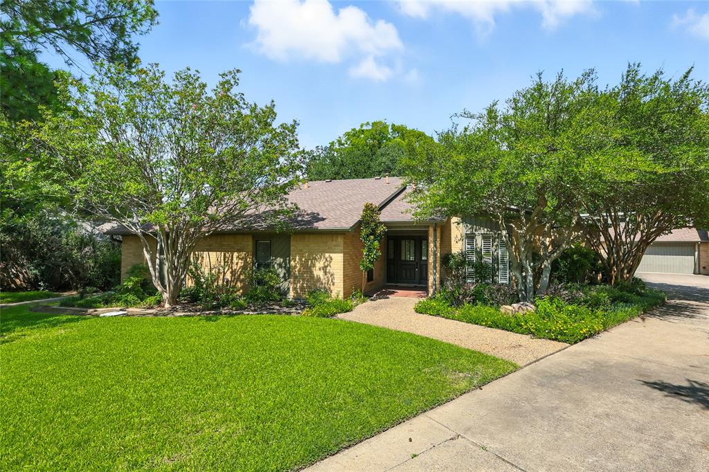 One-Story Retreat with 5-Car Garage on a Creek Lot Offering Casual Comfort and Space at the End of a Cul-de-Sac.
If you’re looking for a roomy, inviting one-story custom home with tons of character, this property at the end of a cul-de-sac checks all the boxes. You’ll love the huge family room with its warm wood-paneled walls and soaring brick fireplace with built-ins and a wall of windows overlooking the backyard—perfect for relaxing or entertaining. The big kitchen comes with granite countertops, breakfast bar, double ovens, a microwave, a spacious pantry, and even an ice maker. The large primary suite offers dual vanities, a separate tub and shower, and two walk-in closets, giving you all the space you need to spread out. Down the hall, you will find two secondary bedrooms with a split bath and walk-in closets. With four bedrooms and three baths, there’s plenty of room for family or guests. Step into the sunroom and take in the backyard views or relax on the screened patio while you enjoy the sounds of the birds or wind blowing through the trees. The oversized FIVE-CAR GARAGE is great for car lovers, boat owners, hobbyists, or anyone who needs extra storage. With great schools, fantastic location, minutes away from I-35, Lake Lewisville, shopping, and dining, this one-owner home offers an amazing opportunity! THE ONLY THING MISSING IS YOU! Seller is a licensed Texas Real Estate Broker. Listing Agent is Related to Seller.