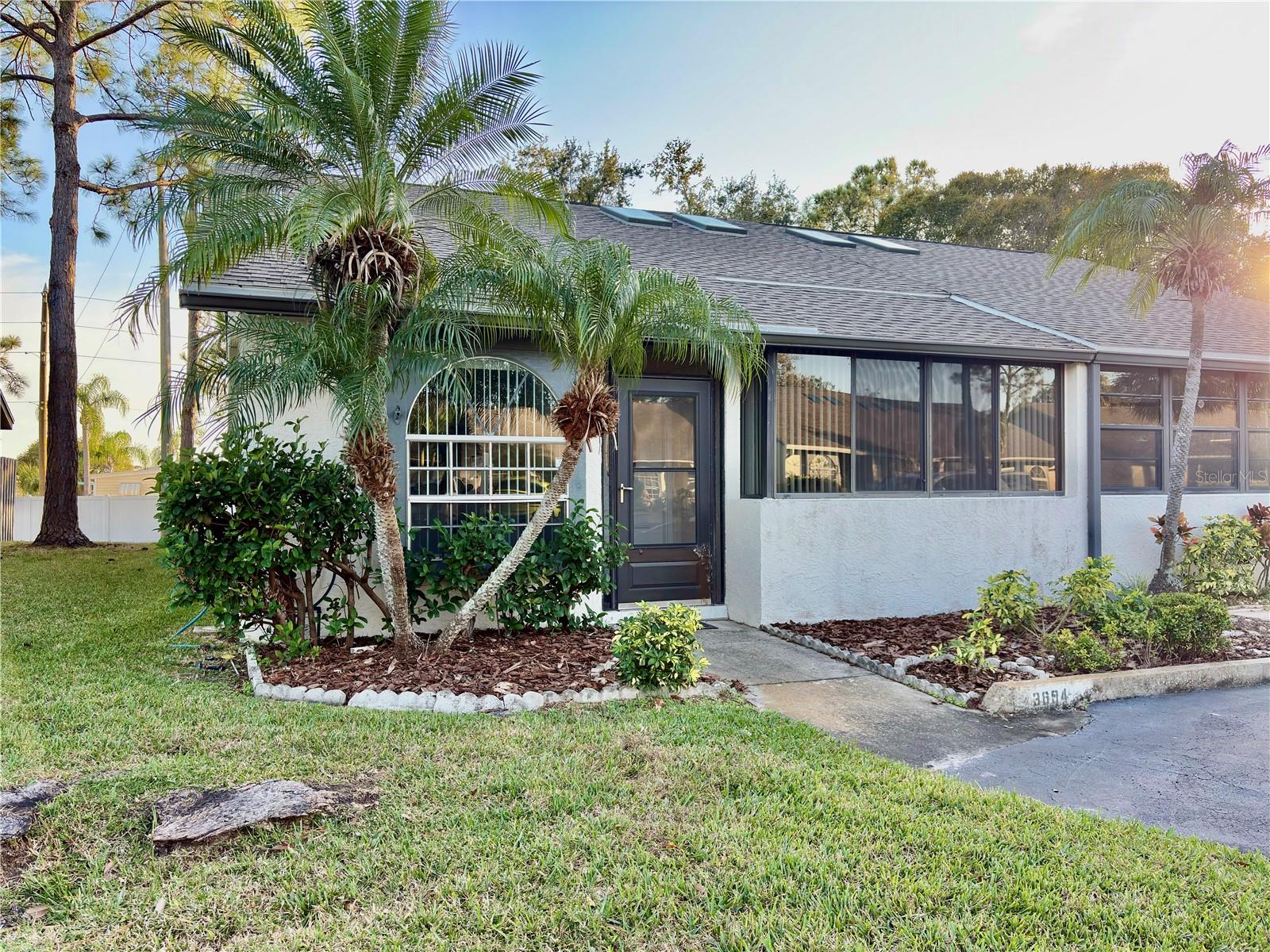 Tastefully updated villa centrally located in a private, gated community with 2 pools, pool house and picturesque ponds. With a new roof in 2024, new luxury vinyl plank flooring throughout, new lighting and fixtures, freshly painted, in unit laundry, sunroom or office space, this end unit is ready to move in! Low dues of $88 per month ($264 per quarter). Pets are welcome here.  A lovely community just minutes to area beaches, shopping, restaurants, schools, only 30 minutes to TPA, 13 mins to PIE.