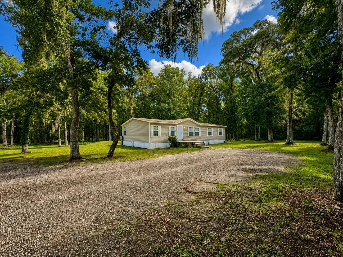 Enjoy peaceful country living with the convenience of nearby shopping, dining, and easy access to the Suncoast Parkway. This 3-bedroom, 2-bath 2009 manufactured home is privately situated on an expansive 3.8-acre lot on Citrus Way in Brooksville, offering plenty of space and privacy.Inside, you'll find a bright and open split-bedroom floor plan designed for comfortable everyday living. The spacious kitchen features wood cabinetry, a pantry closet, center island/breakfast bar, and ample cabinet and counter space, all opening to the main living area. Laminate flooring throughout, crown molding, and double-pane windows add to the home's appeal.The large primary suite provides a private retreat with a huge walk-in closet and an impressive en-suite bathroom featuring dual sinks, a soaking tub, and a separate shower. The split floor plan offers privacy for family members or guests.Additional highlights include a new roof installed in 2024, AC replaced in 2022, private well, and septic system. Enjoy the rare opportunity to have nearly four acres of private land while remaining just minutes from everyday conveniences.Whether you're looking for room to spread out, enjoy the outdoors, or simply escape the hustle and bustle, this Brooksville property offers the space, privacy, and convenience you've been searching for. Schedule your private showing today!