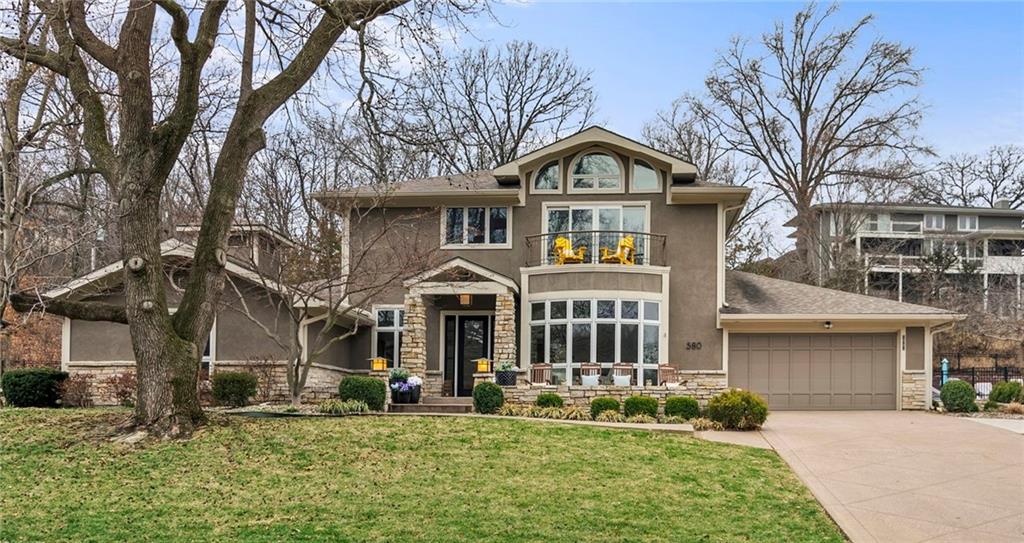 Experience everyday living that feels like a getaway. This stunning lakefront home is filled with natural sunlight & showcase lake views that bring the outdoors in. Significant Updates & Improvements to the Main Lvl, Finished Lower Lvl & Garage make this home a Perfect setting for both relaxing & unforgettable entertaining. Walk into the Grand Front Entrance with Natural Stone Travertine Flooring & High Ceilings. Enjoy gatherings in the Formal Dining overlooking the lake. The Large Great Rm with Natural Gas Stone Fireplace, High Ceiling with Natural Wood Beams & Wall of Windows with Nice Architectural Details. The Open Kitchen Showcases a Large Island with Honed Granite & Counters, SS Appliances, 5-Burner Gas Cooktop, Warming Drawer, New Dishwasher, New Beverage Fridge & a Walk-In Pantry. Just off the Kitchen is a Spacious Updated Laundry/Mudrm/Home Office with Blt-Ins & Dedicated Desk Area with New Checkered Tile Flooring. The Main Level Offers 3 Bedrms, All with Newer Laminate Flooring & a Jack-in-Jill Bathrm between 2 Bedrms. Both main floor Bathrms have been updated with New Showers & Natural Stone Counters. Additional upgrades to the Upper Lvl Primary Suite have Just Been Completed. The Upper-Level Primary Suite is a Private Retreat, Complete with a Loft with Built-Ins, Separate Sitting Area, 2 Walk-In Closets & Private Office.T he Primary Bath Includes Dual Vanities with New Countertops, Newer Soaker Tub & a Large Walk-In Shower with 2 Shower Heads. Secondary Closet Off Primary Bedrm May Be Adaptable to a 2nd Laundry Area. Office Off Primary Bedrm May Accommodate a Lift or Elevator from the Laundry Area Off the Kitchen & Garage (Buyer to Confirm). The Finished Lower Lvl Features New Laminate Flooring, Exercise Rm (Easily Used as a Non-Conforming 5th Bedrm), New Half Bth, Wine Rm Area & Ample Storage. 1x $40,000 Lake Quivira Required Membership Fee.  Dock Site #222