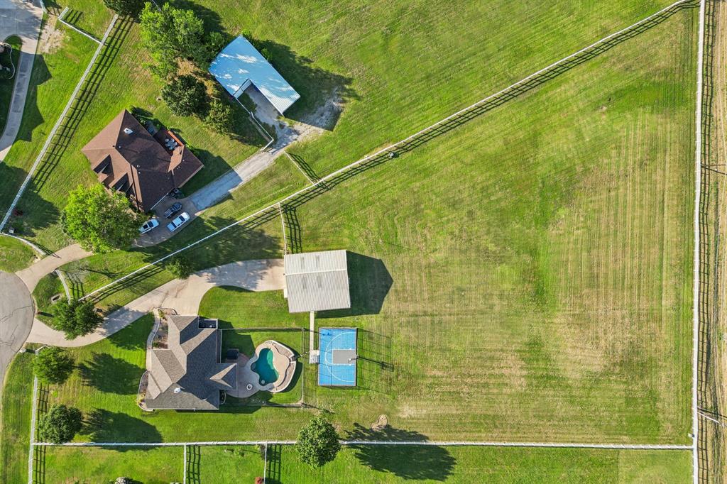 Live the dream in gated Fossil Creek Estates—an equestrian-friendly community with 50+ acres of scenic trails, a lit arena, round pen, fishing ponds, playground, and baseball field. This 2.8-acre retreat blends modern comfort with outdoor adventure. Inside, enjoy quartz counters, luxury vinyl plank floors, plantation shutters, shiplap fireplace, and a charming built-in loft bed. The kitchen shines with SS appliances, farmhouse sink, and open flow to the living area. Outside, splash in the saltwater pool with built-in table and water features, shoot hoops on the sport court, or grill out in the outdoor kitchen. Relax under the stars in the spa, by the fire pit, or from the separate hot tub. A 30×40 insulated shop with power, pull-through garage doors, and 2 horse stalls offers exceptional versatility—perfect for equestrian needs, boat or RV storage, a car collection, home gym, workshop, or hobby space. Per HOA guidelines, up to 4 horses are allowed on the property. Fully fenced and perfect for families who love space to roam. Just 10 min to Alliance Town Center, 25 min to downtown Fort Worth, and 10 min to Eagle Mountain Lake—this is Texas living at its best.