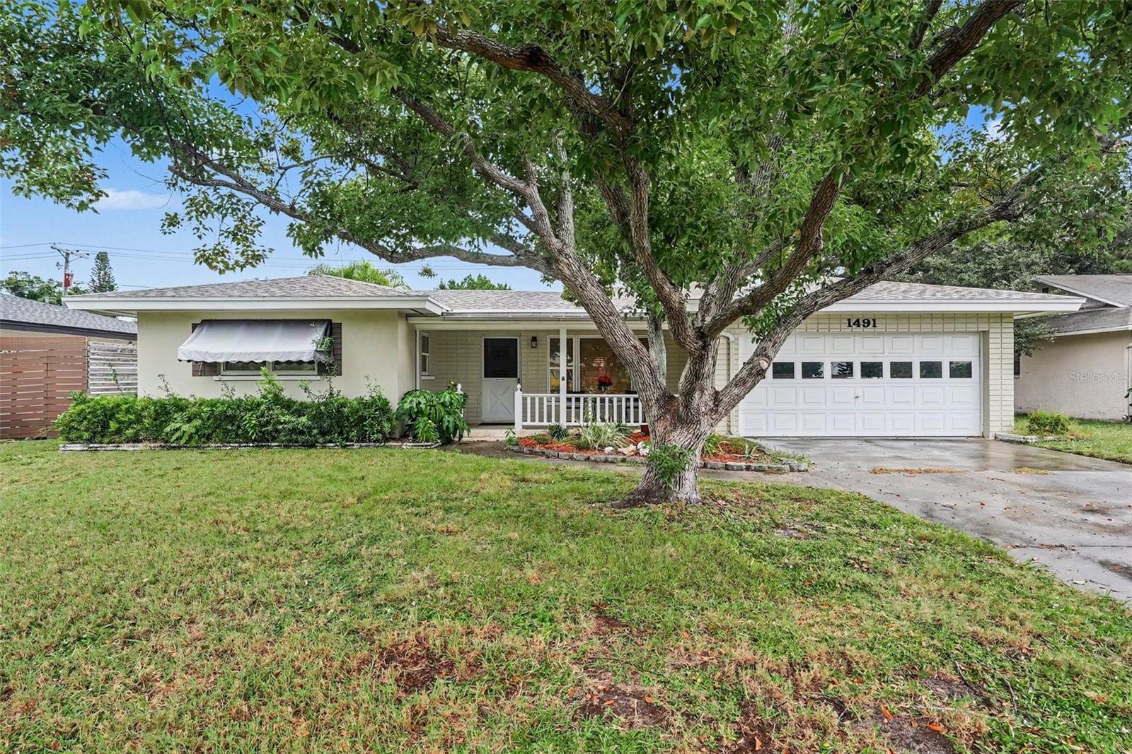 Welcome to easy Florida living with plenty of space to enjoy both indoors and out. This inviting home features a comfortable, light-filled layout with warm flooring, generous living and dining areas, and a spacious kitchen offering abundant cabinetry, ample counter space, and room for casual seating. Large windows throughout bring in natural light and offer views of the outdoor spaces. The bedrooms provide comfortable retreats, while the home also includes a dedicated laundry area for everyday convenience. Outside is where this property truly shines. Relax on the charming covered front porch, enjoy the screened patio for year-round outdoor living, or spend sunny Florida days beside the private screened-in pool. Beyond the pool area, additional patio and yard space surrounded by mature landscaping provides even more room to relax, entertain, or enjoy the outdoors. With multiple indoor and outdoor gathering spaces and a welcoming Florida feel, this home is ready for its next chapter.