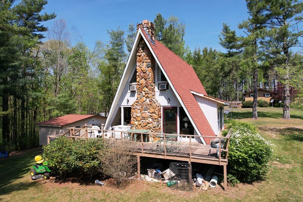 Charming A-frame home full of character in the desirable Chalet High subdivision! Chalet High amenities include swimming pool, tennis & basketball courts, 2 fishing ponds, playground with a shuffleboard court, area for your trash and clubhouse. This 3-bedroom, 2-bath mostly furnished retreat offers a warm and inviting atmosphere with its classic architectural style and cozy interior layout. Recent updates include a newer heat pump, shower, new wraparound deck, and roof. Outside you have a spacious outbuilding for storage or a workshop, huge deck to enjoy the sunshine and mountain air. Conveniently located just off the Blue Ridge Parkway, this home offers easy access to outdoor recreation and scenic views. Commuters will appreciate being only 10 minutes from I-77 and 5 minutes from US-52, while the vibrant town of Mount Airy, NC is just a 25-minute drive away. Whether you're looking for a full-time residence or weekend getaway this unique property combines comfort and charm.