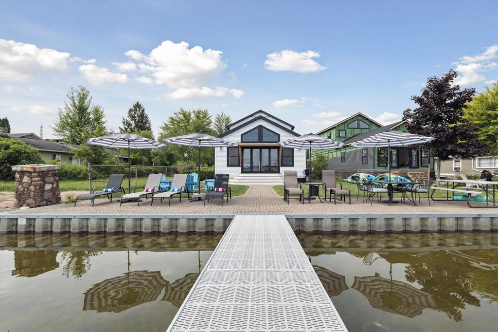 Brand new, turn-key luxury on Portage Lake. Wake up to shimmering waterfront views and enjoy coffee from your private patio, where every day feels like a five-star retreat. Designed with both elegance and comfort in mind, this stunning home offers 5 spacious bedrooms, including 2 private primary suites, and 4 spa-inspired baths. The open-concept living space is filled with natural light and elevated by expansive accordion doors that seamlessly blend indoor and outdoor living, framing breathtaking lake views. High-end finishes and thoughtful design create an effortless flow perfect for entertaining or relaxing in style. Step outside to your expansive private dock, ready for sunset cruises and days on the water. With 800 feet of lake bottom ownership, this is more than a home, it's an exclusive waterfront lifestyle.