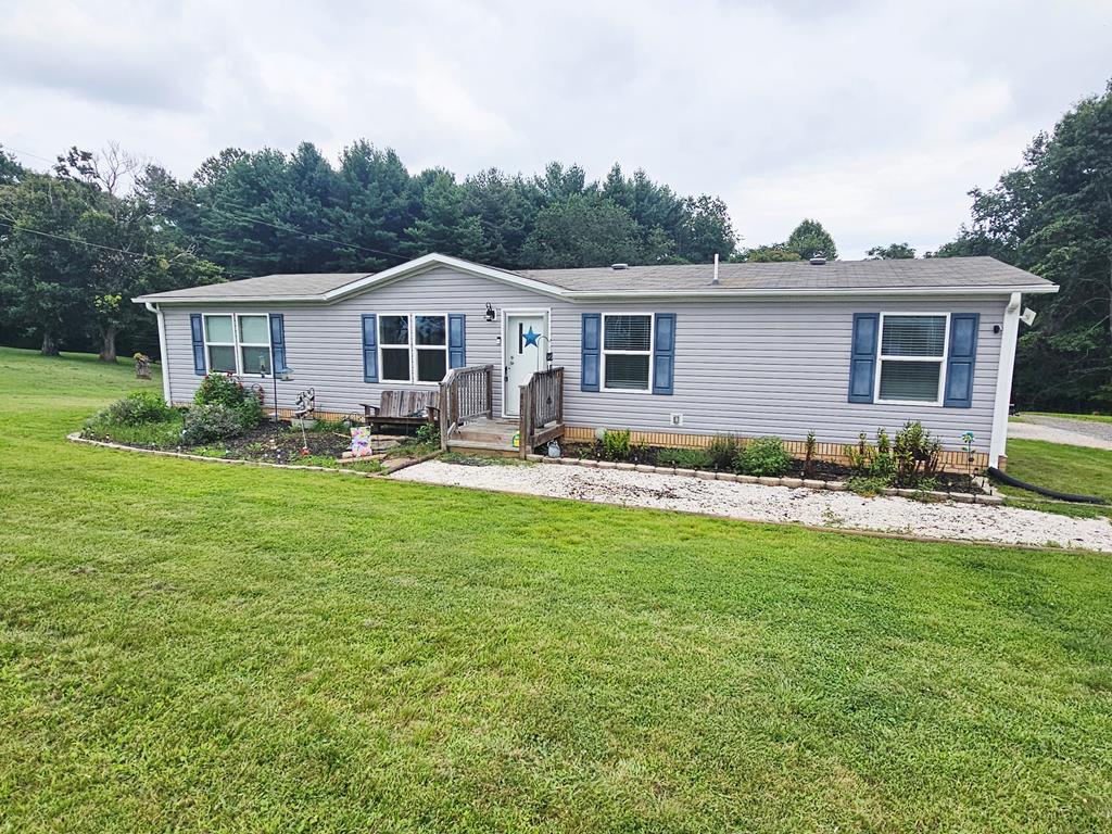 Don't miss this well-kept 4 bedroom, 2 bath doublewide home situated on a beautiful level lot! Built in 2020, this home offers an open-concept floor plan for comfortable living and entertaining. The heart of the home features a spacious living area that flows seamlessly into the dining area and a modern kitchen with a center island – ideal for family meals or hosting guests. The generous primary suite is tucked away on one side of the home for privacy and includes a large walk-in closet, double vanity, garden tub combo with shower. On the opposite side, you'll find three additional bedrooms and a full bath with a shower/tub combo – for kids or guests. A sizable laundry room is conveniently located just off the kitchen. Additional features include: county water and private septic & good access to I-77, Hillsville and Galax. Move-in ready and waiting for you – call today to schedule your showing!