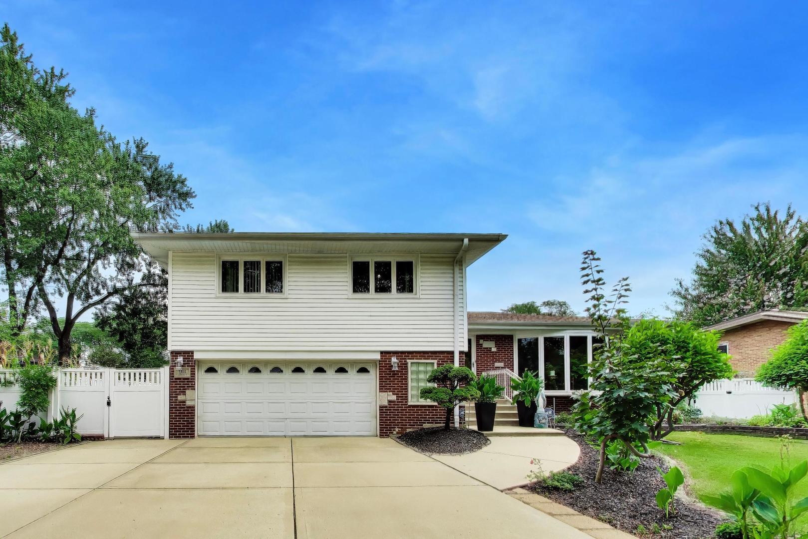 Impressive proud standing Tri-level home with a finished sub-basement and walk-out family room - all on a 93 foot wide lot. Originally built 4 bedroom home with a 2.5 car attached garage (was converted to a 3 bedroom with large primary bedroom - could be walled back if desired). Beautiful hardwood floors throughout, newer windows, recessed lighting and updated bathrooms. Nice kitchen with all stainless steel appliances, granite counter top & table eating area and quality oak cabinets. Lots of updates throughout: 2 years new white privacy fence (maintenance free), Roof (tear-off 5 yrs, concrete driveway and extra parking pad approx 12 yrs, Windows (vinyl - insulated - wood frames), Siding, gutters (5-7yrs), all new installed hardwood floors throughout main level and bedrooms - 7yrs, furnace & central air replaced - approximately 9yrs,  Ring doorbell system and cameras will remain with home. Gardener? Always wanted aa active coy pond (approx 30'x20') or running brook type fountain? Retreat Like backyard? Fruit Trees (Korean plum, Japanese sugar plum, peach, apple and more plantings...Then this is a must see. Plenty of parking - 3 wide + concrete driveway with turn around.