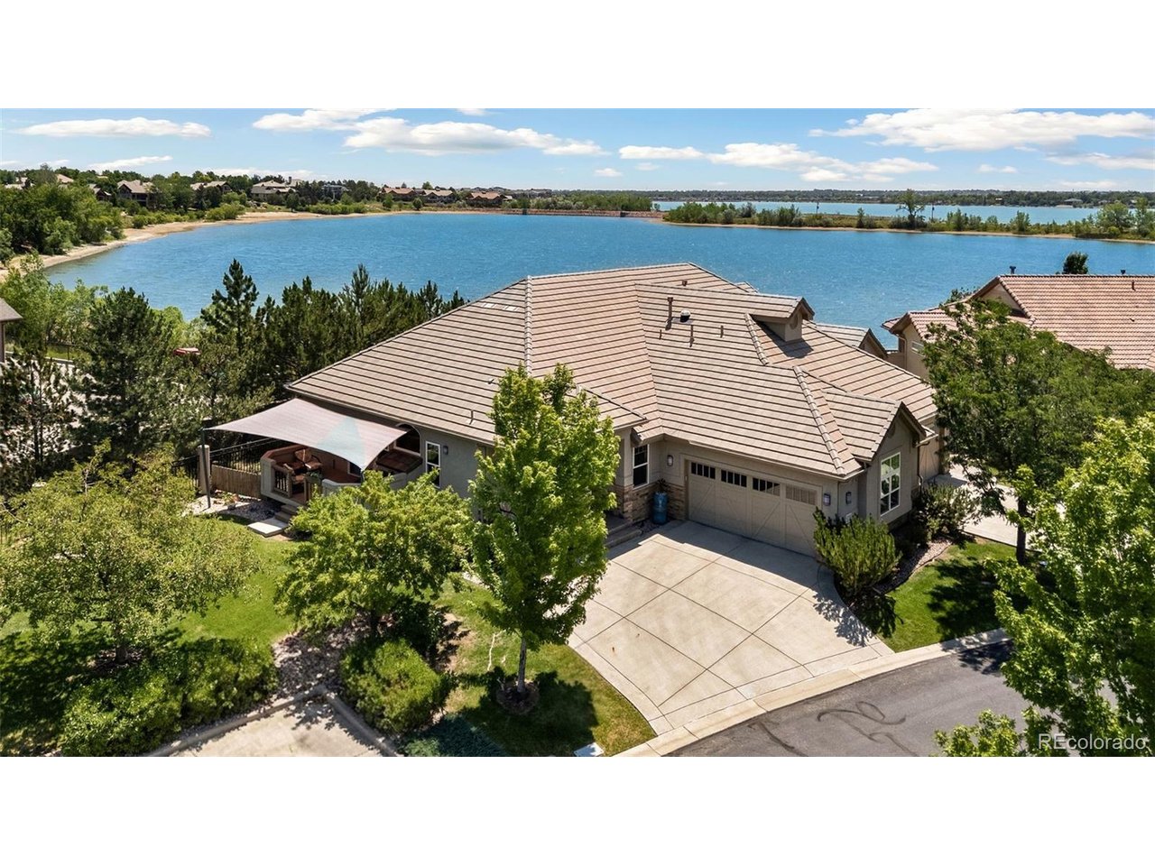 Wake up to sweeping mountain views and close to Buckingham Lake in this rare, maintenance-free end-unit ranch offering easy, lock-and-leave or stay-and-play living in desirable and active Mariana Butte in Loveland CO. Open and airy main level boasts vaulted ceilings, gas fireplace, expansive windows, plantation shutters, and dining area with deck access. Deck opens to green space with lovely mountain views and includes study posts for solar shades. Gourmet kitchen features quartz counters, tile backsplash, granite composite sink, built-in oven and microwave, XL gas cooktop, and large island. Gorgeous primary suite captures lake views and includes a spa-like bath with oversized designer shower, grand double vanity, private water closet, and oversized walk-in closet with custom shelving and solar tube. Main level also includes an office, powder bath, and dedicated laundry room with sink and abundant cabinetry. Well-designed garden-level basement with picturesque lake views features a spacious living room with gas fireplace. Bedrooms 2 and 3 share an upgraded bath with large tub, extended vanity, tile flooring and tub surround, ensuite access from Bedroom 2 plus hall entry. Dog run provides a convenient space for furry friends. Ample storage including basement storage room and 2-car garage.Thoughtfully designed to combine effortless, low-maintenance living with exceptional views and everyday functionality.