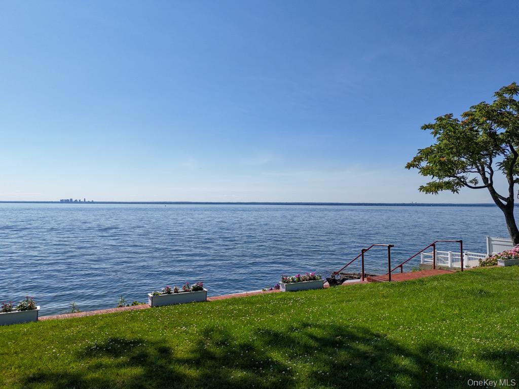 A Hamptons alternative with exceptional waterfront serenity, this expanded brick ranch offers breathtaking 180-degree views of Long Island Sound, spectacular sunsets, the Manhattan skyline, and passing boats. Located on iconic East Island (Morgan’s Island)—once owned entirely by J.P. Morgan Jr.—residents enjoy a private boat launch and exclusive access to two beaches.Renovated in 2005 and meticulously maintained, the home features hardwood floors throughout and dramatic wall of windows across the rear as well as the Primary bedroom, maximizing the stunning waterfront views.The home offers 4 bedrooms, including a luxurious primary suite with radiant-heated bath with soaking tub, spa shower, and towel warmer, two walk-in closets, and panoramic western water views. Two additional bedrooms and hall bath are on the main level, while the second floor features a private guest bedroom with a full bath and abundant storage.The spacious kitchen includes a center island, granite countertops, Terra Cotta quarry tile flooring, a walk-in pantry, Sub-Zero refrigerator, Miele dishwasher, and garbage disposal. The living room with a propane fireplace and the dining room with custom built-ins showcases sweeping water views.Additional highlights include two laundry rooms (main and upper levels), an attached two-car garage, burglar and fire alarm systems, four-zone central air, a four-zone Buderus oil-fired heating system, a brand-new hot water heater, and a whole-house generator.  NOT IN A FLOOD ZONE!