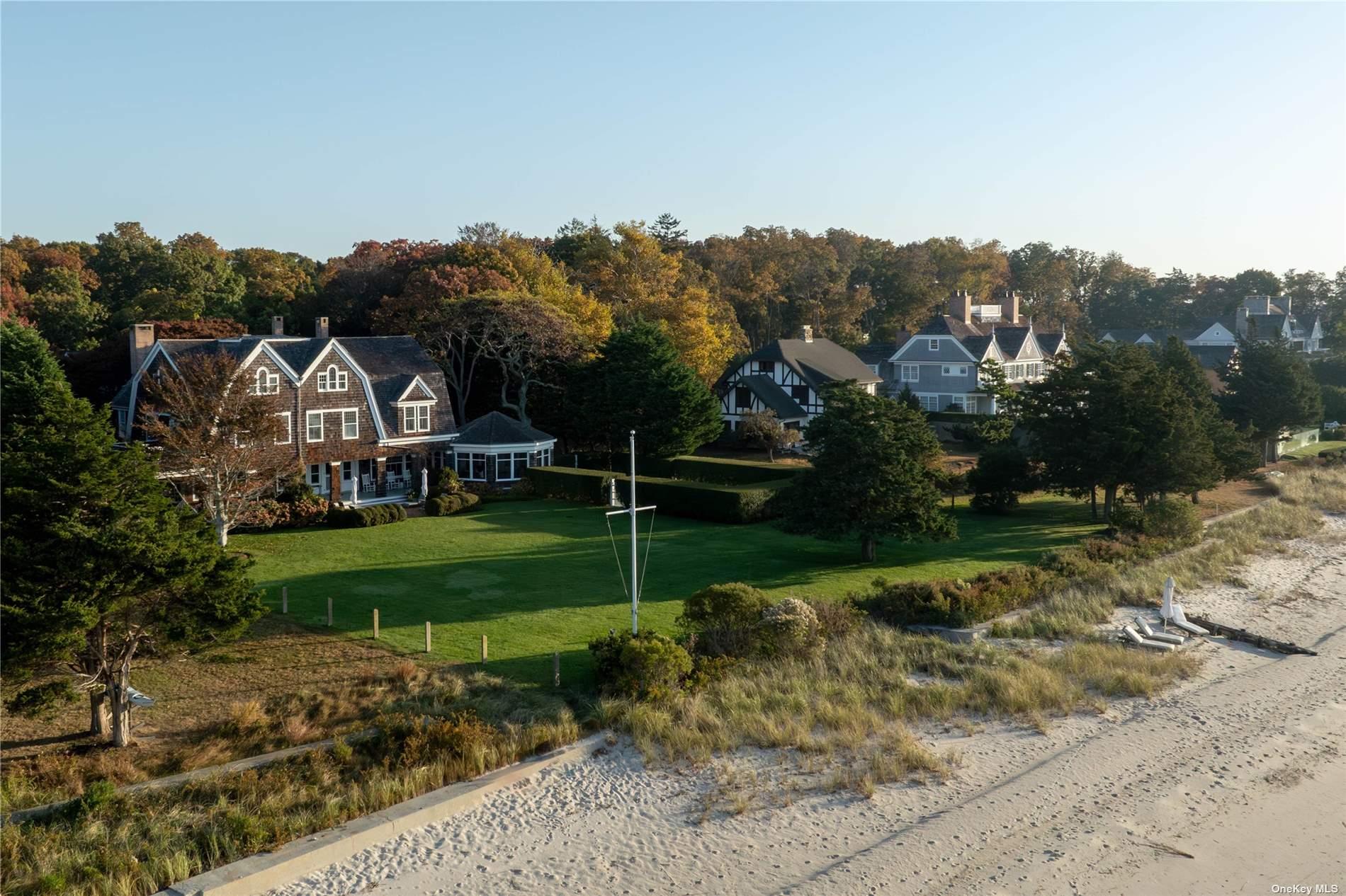 The estate of the late legendary New York art dealer Barbara Gladstone, this meticulously restored Gilded Age shingle-style home offers a rare opportunity to own one of the few remaining large, turn-of-the-century North Fork summer estates. Set on 140 feet of pristine bayfront with a private sandy beach, the primary residence spans over 10,000 sq. ft. and seamlessly blends period architecture with modern luxury. Every element, from the doorknobs to the custom hardware, has been carefully curated, resulting in a warm, classic home defined by craftsmanship and elegance.

Well suited for both grand entertaining and intimate gatherings, expansive living spaces feature soaring ceilings, multiple fireplaces, and thoughtfully designed moments throughout. Highlights on the first floor include a large waterside living room and dining room with charming fireplace alcoves, a sprawling chef's kitchen with breakfast room and handsome butler's pantry, a dedicated flower-cutting room with custom marble sink, and an enormous screened-in outdoor sitting porch complete with an outdoor dining room and kitchen. 
 The second floor houses the large primary suite with an ensuite bath, extensive walk-in closets, a dressing room, and a cozy sitting room with an oversized fireplace. The balance of the second and third floors includes five additional waterside bedrooms, a library, an office, multiple wet bars, a laundry room, and five baths with steam showers and soaking tubs.

Outside, lush, professionally designed perennial gardens and hedged lawns surround the property. A beautiful, private gunite pool sits on the waterside, offering a serene oasis overlooking the bay. Just beyond, a sweeping lawn with panoramic water views leads to a sandy path framed by sea grasses and wildflowers, guiding you down to the private bayfront beach. A charming carriage house adds further versatility, featuring a great room, home theater, and gym. The estate also includes a historic icehouse, preserving its rich legacy. Whether sitting by the bay, hosting holidays, or enjoying movie nights in the theater, this extraordinary property promises a lifestyle of laid-back elegance and tranquility.