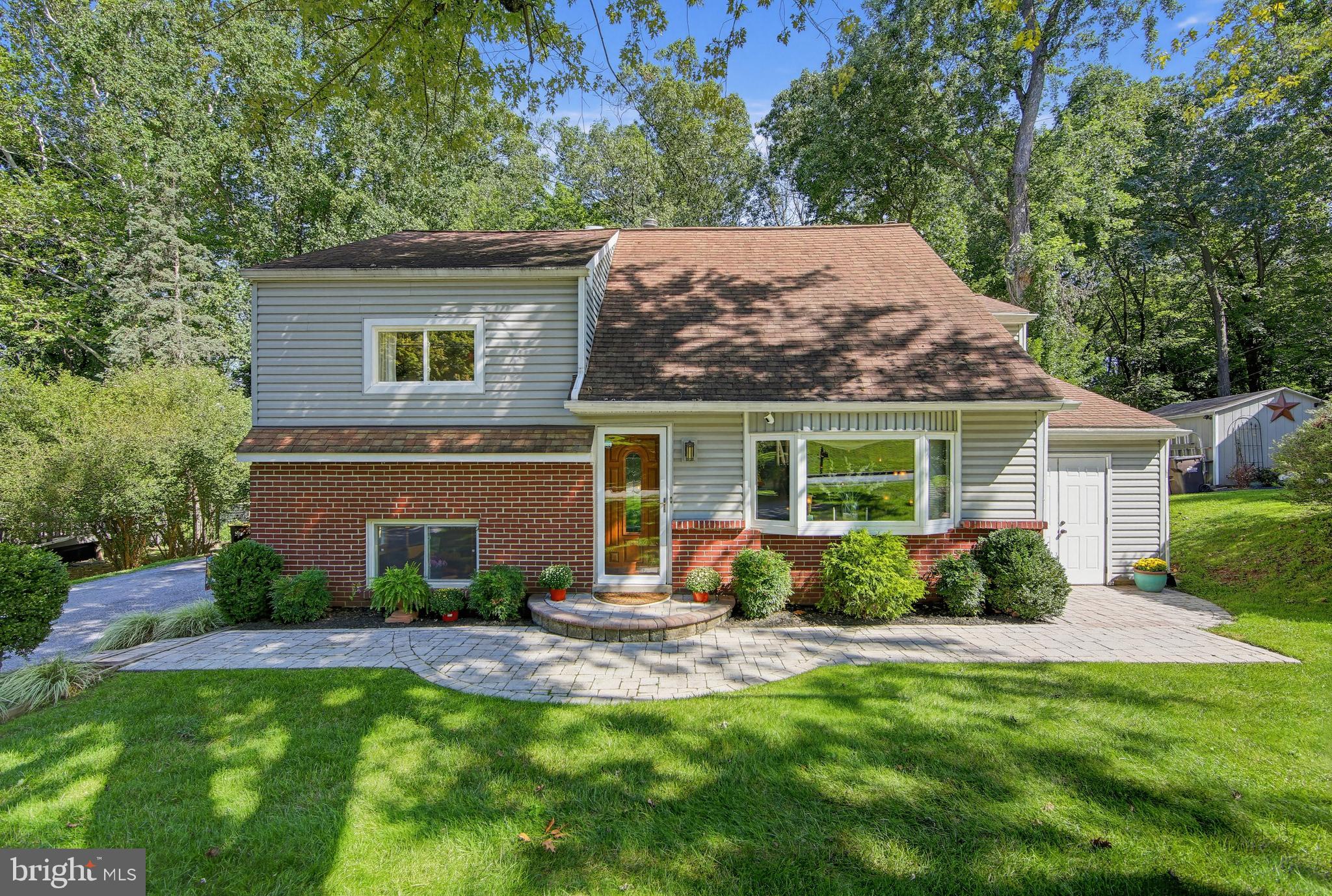 Welcome Home to this Beautiful Well Maintained 4 Bedroom, 3 Bath Split Level Home with an expanded driveway.  The level entry way to the home is very inviting and nicely landscaped.   The Living Room has hardwood floors, a bay window with remote blinds and a painted a neutral palette.   Leaving the Living Room, you enter a "cozy" sanctuary/sitting room with gas fireplace, built-in bar, hardwood floors and a lovely coffered ceiling with recessed lighting.   The Kitchen/Dining area has been remodeled/updated with hardwood floors , recessed lighting, quartz countertops, stainless steel appliances, gas stove/electric oven with beautiful tiled work in back of oven,  utility sink and a window over the sink offering a spectacular view of the woods.    A door off the kitchen offers a walk-in closet with shelves/drawers and a nice work-shop room.   Going out the back of the kitchen, you will find 2 pantries (one built-in) and refrigerator/freezer. Coming in the back door is a mud-room area.  The basement is paneled, berber carpets, recessed lighting, pull out shelves for storage and a gas heater (2019).  A full-bath is also located in the basement with shower and one-sink vanity.    Going up to the second floor, you will find the first bedroom that is carpeted, a built-in bed and ceiling fan.  The second bedroom has hardwood floors and has many options for use.   The Hall bathroom has a one-sink vanity, tiled floor and tub/shower combination.     Going up to the third floor, a third bedroom has been recently painted and can also be used as an office den, etc.  A door in this room leads up the attic which has a Cedar Closet and "ample storage".    The "Primary Bedroom" is a tranquil retreat, offering a ceiling fan, gas fireplace, built-in TV above the fireplace, carpeted and a "large" walk-in closet.  There is a small deck off the sliders, giving you extra privacy for morning coffee or just siting out relaxing with a lovely view of the woods.  There is an adjoining room off the Primary Bedroom that can be used as a nursery, reading/sewing room or whatever your pleasure.   The Primary Bathroom has a tiled floor, Jacuzzi/Soaker Tub, two sink vanity and a "double shower".  The laundry room is located off the Primary Bathroom.    The back of the house is a true entertaining paradise or just sitting out and relaxing offering great views of the woods and is very private.  Going out the kitchen sliders, you step onto a large deck with steps leading down to a large circular stone area.  There are more steps leading down into the wooded area with a fire pit.  The back area has lights that are built-in making this enchanting and luminous at night.   Under the deck area is pull-out storage for chairs, tables, etc.     The large shed has 7 doors offering more ample storage as well as a GardenShed.    This home has been very well maintained and OFFERS TONS OF STORAGE!!What are you Waiting For, Come Make this Lovely Home Yours!!