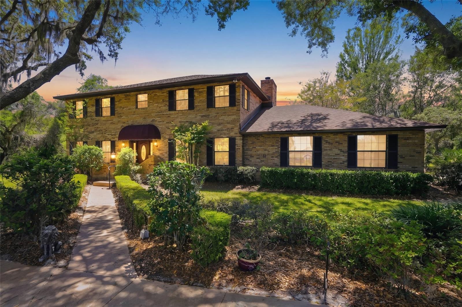 One or more photo(s) has been virtually staged. Welcome to this Beautiful 4 Bedroom 3 Bath custom-built brick estate set on 1.2 acres of lush, mature landscaping. Surrounded by grand oak trees and natural beauty, this exceptional property offers a rare sense of privacy and tranquility while remaining conveniently located. From the moment you arrive, a circular driveway, manicured hedges, and an inviting walkway guide you to a warm and welcoming front entrance, complete with a classic covered portico. The home’s traditional two-story design showcases enduring craftsmanship and timeless curb appeal. Inside, you’ll discover 3,744 square feet of spacious living, ideal for both everyday comfort and entertaining. The family room is a standout feature, offering a dramatic floor-to-ceiling brick fireplace complemented by custom built-ins, creating a warm and inviting gathering space. The expansive main bedroom is a true retreat, stretching the full length of the home and featuring its own wood-burning fireplace with a beautiful marble hearth. The eat-in kitchen overlooks the private backyard, providing a peaceful setting for everyday meals. It is equipped with Corian countertops and stainless steel appliances, blending functionality with style.Enjoy year-round relaxation in the large screened-in Florida room, recently enhanced with a stunning wood ceiling that adds warmth and a great place for back yard BBQ's and morning coffee time. Additional features include a spacious laundry room complete with a folding area, as well as a separate office or craft room—perfect for working from home or pursuing hobbies.Built by its original owner and lovingly maintained, this home includes all original plans and documentation—an incredibly rare and valuable feature for future customization or expansion. New Roof installed in 2024! Water Heater 2024, Exterior Paint 2024, A/C (downstair unit) 2024. Underground dog security fencing installed with two separate zones, Irrigation system, Massey termite bond in place for years. This is more than just a home—it’s a legacy property filled with character, space, and opportunity. Perfect for buyers seeking privacy, quality construction, and a place to create lasting memories.