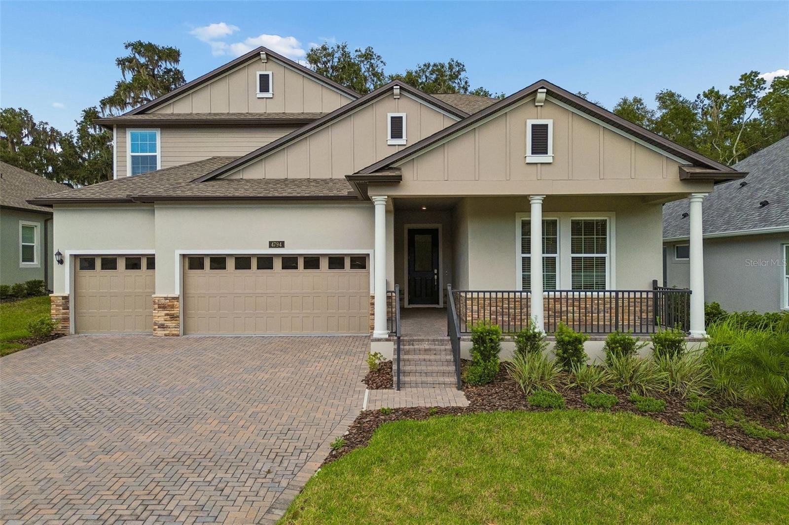 Welcome to a side of Florida you may not expect to find. Set among the rolling hills, mature oaks and beautiful surroundings of Southern Hills, this NEVER-LIVED-IN FORMER MODEL HOME offers 3,890 square feet of thoughtfully designed living space with 5 bedrooms, 4.5 baths, DUAL OWNER'S SUITES and a 3-CAR GARAGE. A welcoming covered front porch opens to an impressive wide foyer, immediately setting the tone for a home filled with architectural detail and designer-selected finishes. At the front of the home, the private second owner's suite includes a large walk-in closet and spacious en suite bath with dual sinks and an oversized walk-in shower, creating an exceptional arrangement for multigenerational living or extended guests. A second first-floor guest bedroom also enjoys its own private en suite bath. Wood-look tile flooring flows throughout the first floor, complemented by crown molding, tray ceilings, decorative wall treatments and distinctive model-home details throughout. At the center of the home, the expansive kitchen and great room are bright, open and designed for gathering. The kitchen features 42-inch upper cabinetry, quartz countertops, an oversized island, stainless vent hood over a gas cooktop, wall oven and microwave, large walk-in pantry and a separate butler's station that makes an ideal coffee or beverage bar. Two sets of sliding doors extend the living space to the covered and screened lanai, where sweeping views across the surrounding hills and toward the distant golf course create a beautiful backdrop. Privately positioned at the rear of the first floor, the primary owner's suite is a standout with a wood-inlay tray ceiling, crown molding and an impressive en suite bath featuring separate dual vanities, soaking tub and large walk-in shower. A convenient drop zone from the garage, dedicated laundry room and stylish powder bath complete the first level. Wood stair treads lead upstairs to an enormous 23' x 16' game room, separate private office, full bath with dual-sink vanity and two generously sized bedrooms, creating an entire second-floor retreat. Even the oversized three-car garage offers impressive ceiling height and excellent potential for elevated storage. Southern Hills offers a setting unlike so many Florida communities, characterized by rolling terrain, mature live oaks, winding streets and panoramic views. The private Southern Hills Plantation Club is centered around an 18-hole Pete Dye Signature championship golf course, with club amenities including dining, resort-style swimming, fitness, tennis, pickleball, spa services and a full calendar of social activities. The Manors offers an appealing low-maintenance lifestyle, with quarterly HOA services that include lawn care, mulch, irrigation, exterior painting and cable/internet. This is more than an opportunity to own the former Solstice model. It is an opportunity to experience one of Brooksville's most distinctive country-club communities in a home that has never been lived in.