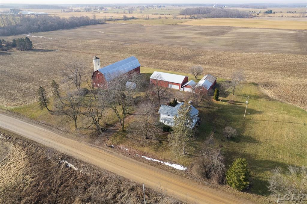 Everything you need to make your farming vision a reality awaits on this exceptional 59.58 acre farm just outside of Adrian, offered below recent appraised value.  This property is well-equipped to be restored to a fully functional farm, featuring a beautiful mix of open tillable farmland, wooded acreage, and a scenic stream running through the property. The four-bedroom, one-bath farmhouse offers a warm and inviting layout with an updated kitchen, spacious living room, and formal dining room with hardwood floors.  Additional highlights include first-floor laundry, an office or craft room on the main level, and major recent updates such as a newer furnace and new roof in 2023, providing peace of mind for years to come. The farm is well supported by an impressive collection of outbuildings, including a 102' x 34' barn with stalls and loft, a farm implement barn with workshop, garage, milkhouse, and an additional shed- ideal for livestock, equipment, and storage. With well-maintained buildings, productive land, and a picturesque setting, this property presents a rare opportunity to own a versatile farmstead with endless potential for agriculture, hobby farming, a hunting retreat or peaceful rural living. BATVAI