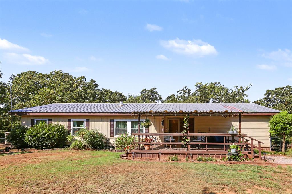 Escape to this secluded 5 acre property just minutes from Lake Thunderbird. This property is peaceful and quiet with all the beauty of country living. Sit out on the covered porch and enjoy the deer that frequent the property. This double wide has new vinyl windows that were installed about a year ago, new vinyl floors through out and fresh paint 2 years ago.  Home has 2 AC units with one being installed a year ago and the other is 6 years old.  Home has 2 living areas, 3 bedrooms and 2 bathrooms. The front living area has a Schrader wood burning fireplace, the second living area has a inground storm shelter, kitchen, 2 dining areas one with built in hutch, large laundry room and lots of storage through out the home. There is a 16 X 20 barn and corral for your livestock with half of the property already fenced. A 25 X 30 workshop with electric and garage door with garage opener and lots of built in shelves for storage and a office and a lean-to with a storage area that is attached with electric. The shop is equipped with a Generac Generator that is setup to power up the home when ever there is a power outage. There is a 16 x 10 storage shed and another 8 x 12 storage shed with electric and shelving. Out back is a 24 x 12 Pavilion, built in horseshoe game and KOI pond with a fountain and plumbed for a water fall. Front yard is fenced with chain link fencing. Propane tanked is owned by seller. Hot water tank is fairly new and the septic tank was pumped a couple of months ago.