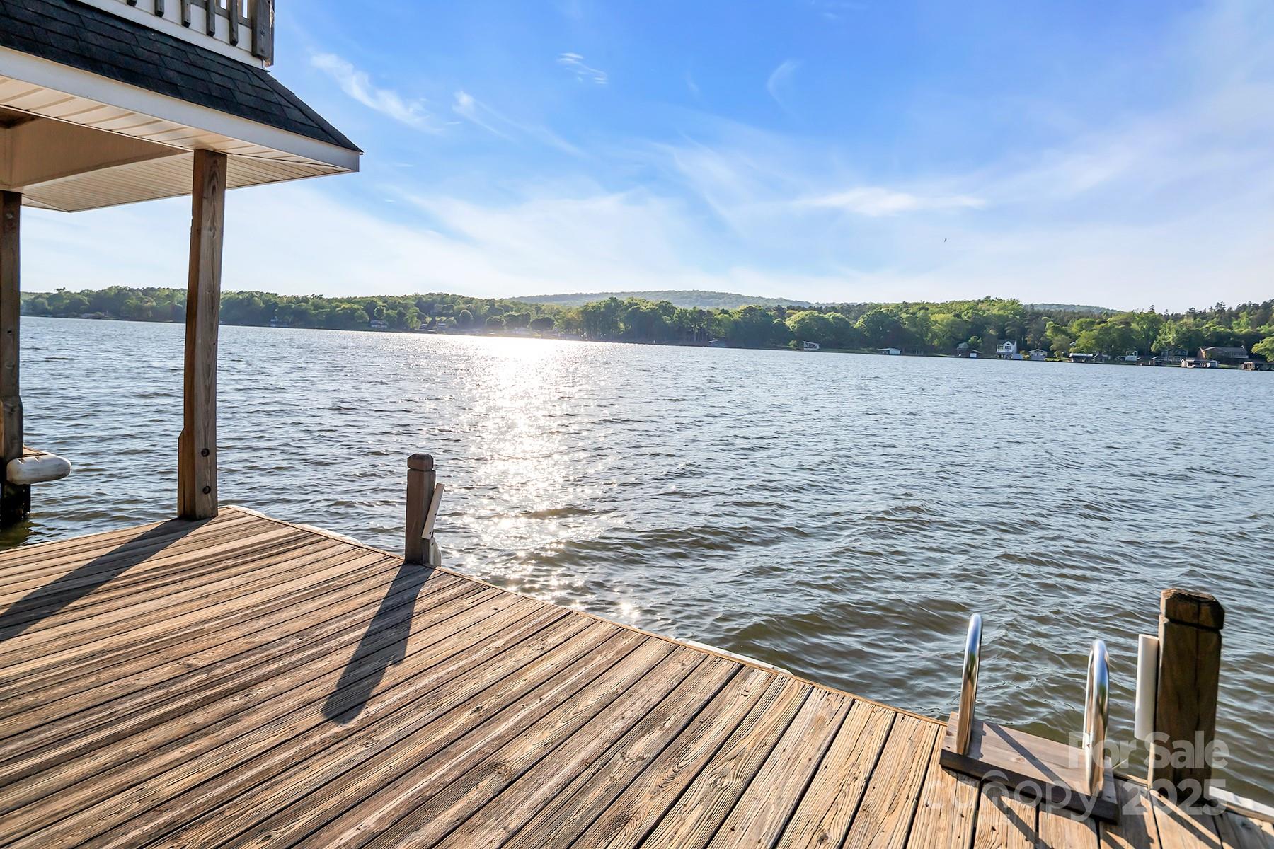 Seize a remarkable investment opportunity w/ this stunning Lake Tillery waterfront home perfect for vacation rentals! This custom built home boasts breathtaking views of the lake & offers a lifestyle that blends luxury & comfort. The home features 4 bedrooms plus a bonus room, 4 full baths, & one 1/2 bath. The interior has exquisite details like wormy maple & oak floors, cedar lined closets, tongue & groove cherry and wormy maple paneling accent walls. Main floor kitchen is equipped w/ solid oak cabinetry, granite countertops, center island & breakfast bar. Cozy up to 2 fireplaces, one adorned w/ dry stack rock, adding warmth to the home. Outdoors you’ll find 3 expansive entertaining areas: an open deck w/ Brazilian hardwoods overlooking the water, a screened porch, and a large covered patio perfect for peaceful relaxation. The property offers a deep water boat house w/ nearly 15 feet of depth, large sun deck, boat slip, & Jet Ski lift. Vacation renters will love this special property!