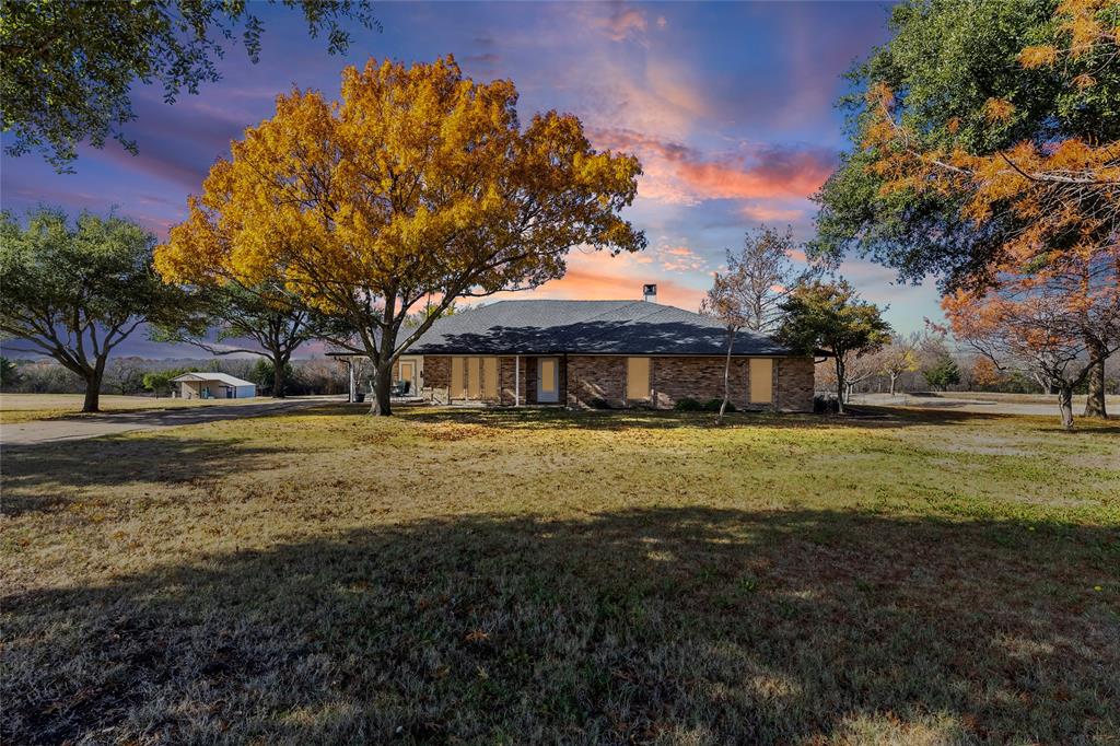 Rare large 1.8-acre lot in sought-after Wylie ISD! With access to Lake Lavon, Collin Park Marina, and Trinity Trails is where you'll find this brick 3 bedroom, 2.5 bath house! Live in the city while feeling like the country. Enjoy a quiet cul-de-sac subdivision with NO HOA on an oversized lot with a pond and pier. Inside, find plenty of room with 3 living areas including an extra-large enclosed sunroom with a wall of windows to the private backyard. Stay cozy on cold winter nights with a wood-burning fireplace in the central living room. The kitchen includes a cooktop, double ovens, dishwasher, stainless steel appliances, built-in desk with glass overhead cabinets, and a breakfast bar. Two dining areas give you room to spread out for family or friend gatherings and meals. A spacious primary ensuite comes with ceiling fan, double sinks, and separate tub and shower. The laundry room has room for 2 refrigerators or freezers. Additional perks are: new glass in windows, spray foam in the attic, variable speed heat pump, dehumidifier, and electricity to pond sprinkler. Keep the lawn green with the full-lawn sprinkler system. You'll also find a great fenced garden spot with automatic sprinklers from the pond and a covered area for plants. Sit outside and watch the wildlife, including an abundance of deer. Feel like you are living in the country, just minutes from Wylie, Lucas, and St. Paul!