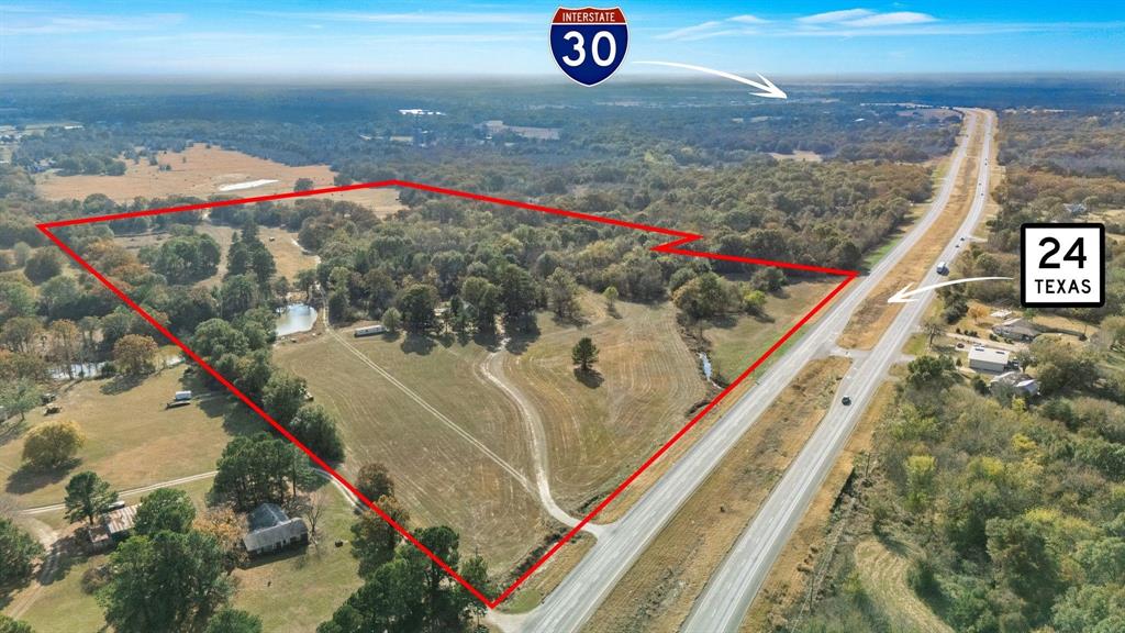 Location, Location, Location! Here is a multi-use property with NO Restrictions allowing the buyer to have the freedom to be creative. Located only minutes from Greenville and Texas A& M Commerce with plenty of highway frontage (over 1100 ft.) for a great business location, possible sub-division, RV park, investment or that visible hilltop location for that new home or horse ranch with quick commute and easy access to DFW area. The deep sandy soil also provides plenty of opportunities for commercial usage or grass and crop production. Currently ag exempt on taxes for hay production. The property is bordered by Timber Creek on the south for natural beauty, privacy and wildlife habitat. Also several ponds on the property for additional surface water and recreation. The useful barn has working pens with alot of new fencing on the back portion of property. .The beautiful rolling hills have scattered towering Pines and majestic Oaks (some est. over 100 years old). The updated  farmhouse provides immediate housing or a possible business asset. With 2 bedrooms, updated kitchen, gas stove, pocket doors, updated natural flooring and covered concrete patio with outdoor fireplace for plenty of entertaining space as a bonus.  This unique property was an old homestead with much history with several small sheds and barns containing many memories of years past. There is a road thru the entire property for easy access. With this location opportunities are unlimited on this diverse hard to find type property. Located only 2 minutes from I30 on Hwy 24 which is the main north south access from Greenville to Commerce, Paris and SE Oklahoma. Bring your business or bring your home plans and your animals. Great visibility and survey available.