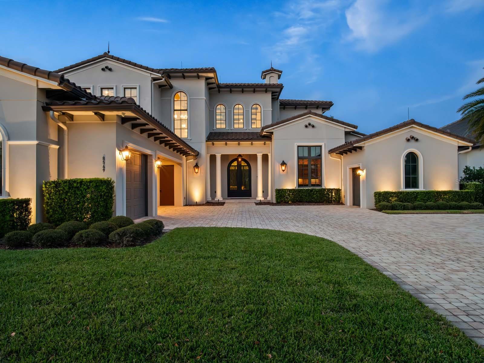Welcome to this exquisite custom-built estate, perfectly situated in the prestigious Lake Nona Golf & Country Club, close to all of the Club’s member amenities and lake access. Built by DeVoe Custom Homes in 2017, this masterpiece offers 5 bedrooms, 5 full and 2 half baths, blending timeless elegance with modern sophistication.Step inside to an expansive family room featuring soaring ceilings, intricate millwork, and 10-foot sliding glass doors that frame breathtaking views of the saltwater pool and serene pond. The open-concept design flows seamlessly into a chef’s kitchen equipped with top-tier appliances, a hidden walk-in pantry, and refined finishes throughout.The luxurious owner’s suite is a private retreat, boasting a spa-inspired bath with a soaking tub, walk-in shower, dual vanities, and a custom-designed closet. The first floor also includes a secondary ensuite bedroom, a dedicated office, a concealed walk-in wine cellar, and a newly converted, air conditioned indoor/outdoor Florida room—perfect for year-round enjoyment.Upstairs, discover three additional ensuite bedrooms, including a hidden fifth bedroom accessed through a secret bookcase door, adding a touch of intrigue and charm. Outdoors, indulge in resort-style living with a spectacular saltwater pool, spa, and outdoor grill, ideal for entertaining or unwinding under the stars. The oversized three-car garage and additional single-car garage provide ample space for vehicles and hobbies.Additional Features Include:  Control4 Automation, Home Organization Room, First and Second Floor Laundry