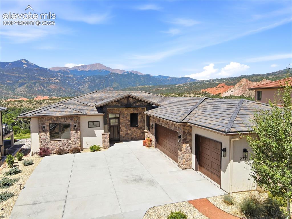 Exceptional custom ranch residence offering breathtaking, unobstructed views of Pikes Peak, Garden of the Gods & Cheyenne Mountain from a coveted rim location in exclusive Cathedral Ridge gated community! Main-level living features zero-step entry, an expansive Great Room w/ floor-to-ceiling stone fireplace, office/bedroom, guest suite w/ en-suite bath, laundry room, mudroom & dog wash. Gourmet kitchen showcases quartz waterfall-edge countertops, KitchenAid stainless steel appliances, oversized island, pot filler, composite granite sink, custom Alder cabinetry & dining area opening to a spectacular outdoor living space. Luxurious primary suite offers private deck access & a spa-inspired bath w/ radiant heated floors, freestanding soaking tub, oversized shower, dual vanities, private water closet & walk-in closet. Covered, 60x15 Trex deck is an entertainer's dream w/ stone gas fireplace & panoramic mountain views. Finished walk-out lower level features a spacious family room w/ wet bar, media/golf simulator room, fitness room, two add'l bedrooms, 3/4 bath, powder room & abundant storage. Covered patio extends to a beautifully landscaped, fenced backyard featuring low-maintenance turf & tranquil water feature. Finishes include hardwood floors, Pella windows, Hunter Douglas automated shades, tile roof, elastomeric stucco, smart thermostat, central air, radon mitigation & oversized 3-car garage. Updates include new light fixtures, interior paint, mudroom, 5th bedroom, back deck improvements, and quartz countertops. HOA includes gated security, private road snow removal & trash service. Steps from Garden of the Gods Club & Resort (membership required), offering premier dining, spa, fitness center, pools, tennis & pickleball. Minutes from Kissing Camels Golf Club, scenic hiking/biking trails & downtown Colorado Springs. A truly rare opportunity to own one of the most coveted vista properties, where unparalleled views, exceptional craftsmanship and refined luxury converge!