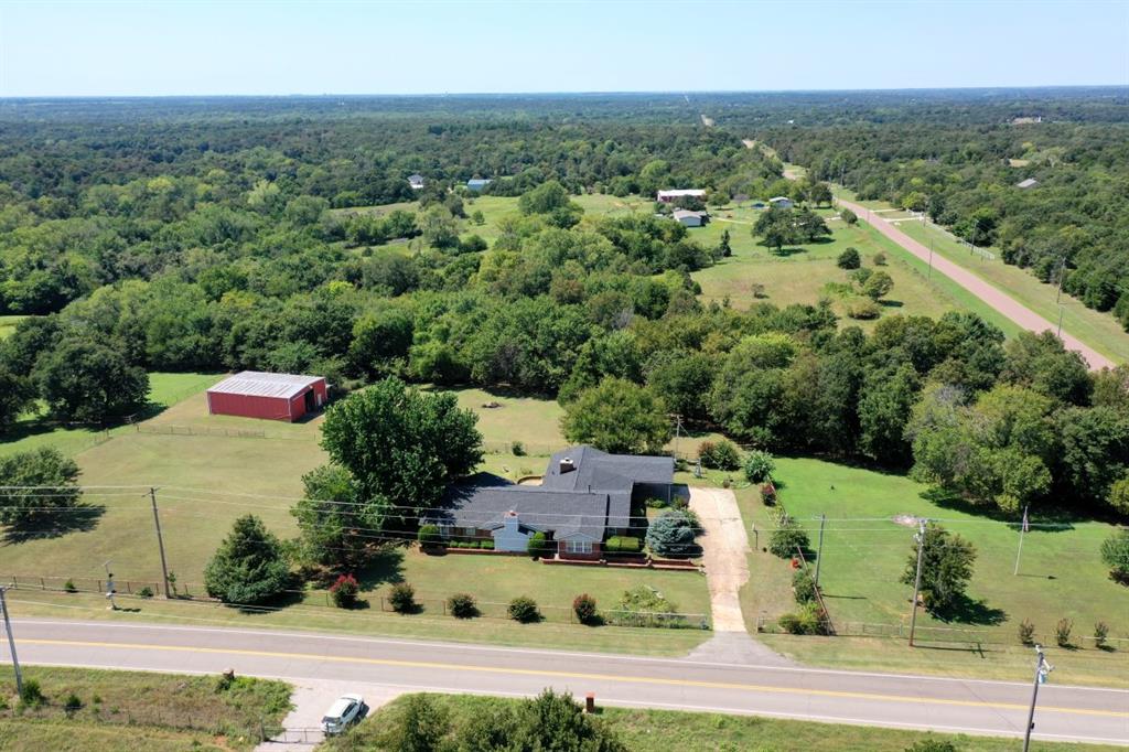 Country Living Awaits! 3 bedroom home in NE Norman on 5 acres MOL, fenced with a barn ready for new owners.  Located on the SW corner of Tecumseh Rd and 108th Ave NE near Lakeview Elementary school.  Barn with stalls and pipe fencing sectioned for livestock.  Well maintained, landscaped and mowed acreage with wooded tree line to the west boundary of the property. 108th Ave on the East, Tecumseh Rd to the North and Lakeview Elementary school to the South. The home has a BRAND NEW HVAC system, PEX plumbing and Composition ROOF installed Spring 2025.  3 bedrooms 3 full bathrooms 2 living rooms (2 fireplaces) and 2 dining rooms with indoor utility room, attached two car garage and carport.  So much space to occupy now or reconfigure to make it your own.  Great bones and new mechanical systems allow the freedom to remodel and focus on the cosmetics of your personal preference.  Minutes from Lake Thunderbird State Park yet still within the City limits of Norman OK. Peaceful setting with wildlife sharing the yard space morning and night.