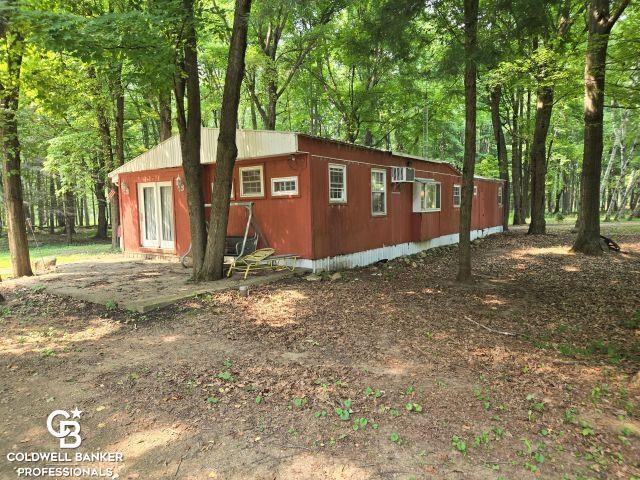 This rural farm of 80 acres is one of a kind!!  The land is the most amazing feature of this property as there is 40+ acres of mature woods that provides an endless supply of firewood and hunting that is unmatched in the area.  There are multiple stands of hand planted pines on the parcel.  Large pond on property for swimming and fishing makes this a sportsman's paradise.  The front half of the property is currently farmed and is subject to tenants crop rights. The property is fenced for livestock.  There is a single wide trailer that is in pretty good shape for the age.  Has a stick built addition on it that could be a third bedroom or additional living area.  The home and buildings sit far off the road providing a secluded setting.  There are 3 outbuildings.  A large detached 3 car garage with additional work shop area added on.  There is a small cattle barn-lean to for livestock.  Lastly, there is a large pole barn that provides great storage or could be used for additional livestock.  No matter where you go on this property, there are amazing sitelines.   Exclude woodstove.